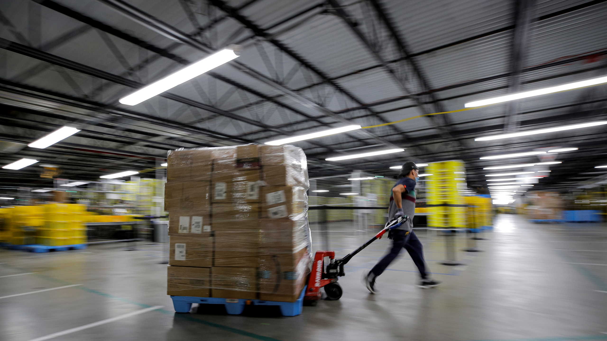 An employee pulls a cart full of items at Amazon's JFK8 distribution center in Staten Island, New York, U.S. November 25, 2020.  REUTERS