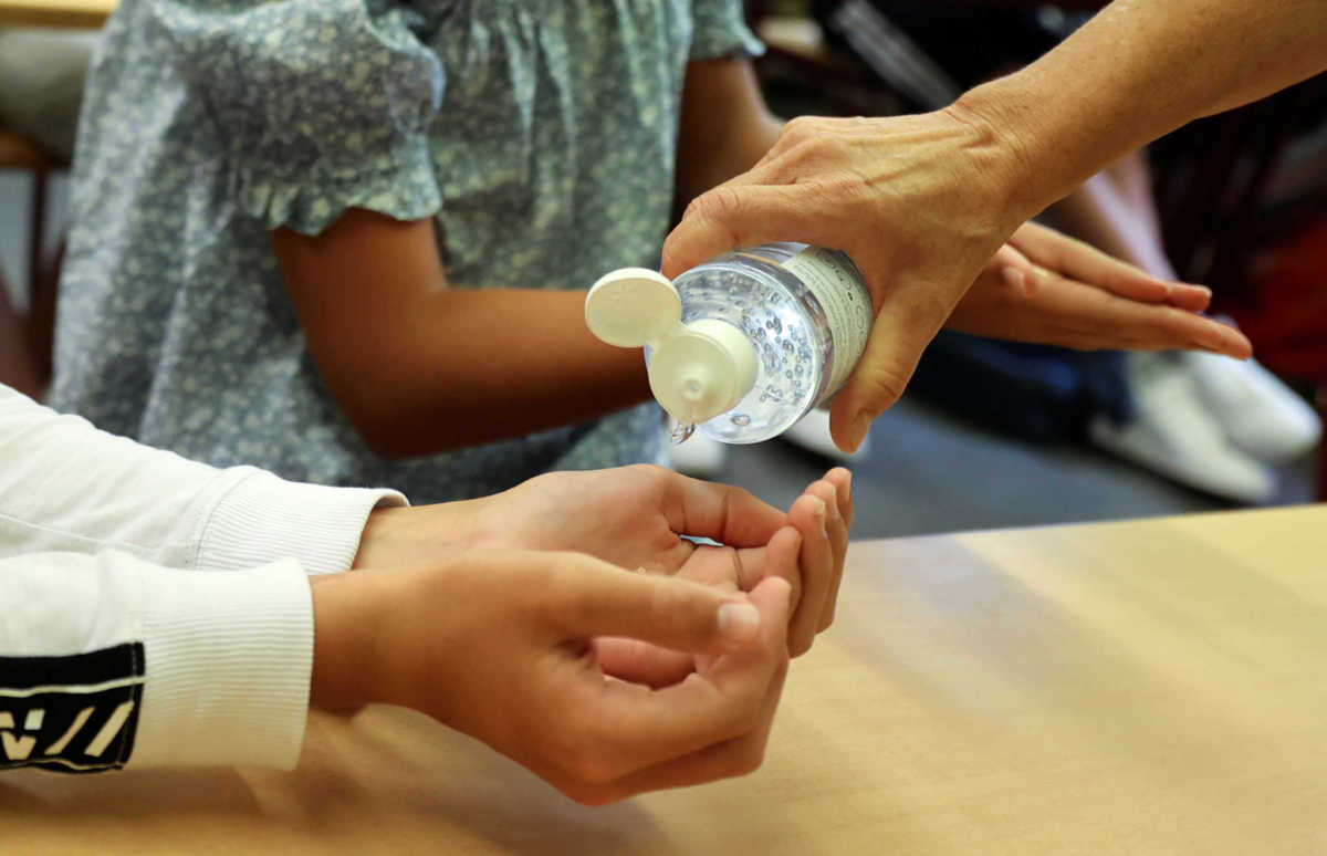 Pupils of the protestant high school "Zum Grauen Kloster" disinfect their hands during a lesson on the first day after the summer holidays, amid the coronavirus disease (COVID-19) pandemic, in Berlin, Germany, August 10, 2020.      REUTERS