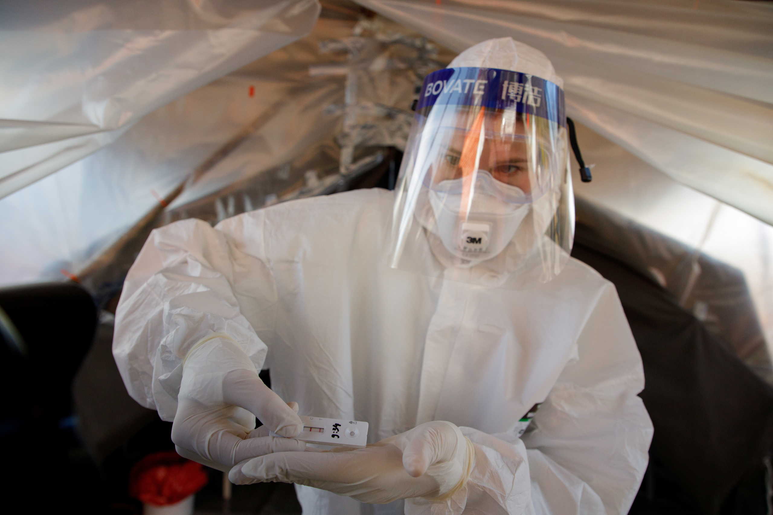 Medical worker shows a positive novel coronavirus antigen test as they prepare to check 60,000 people in Zagreb during the pandemic, in Croatia, November 23, 2020. REUTERS
