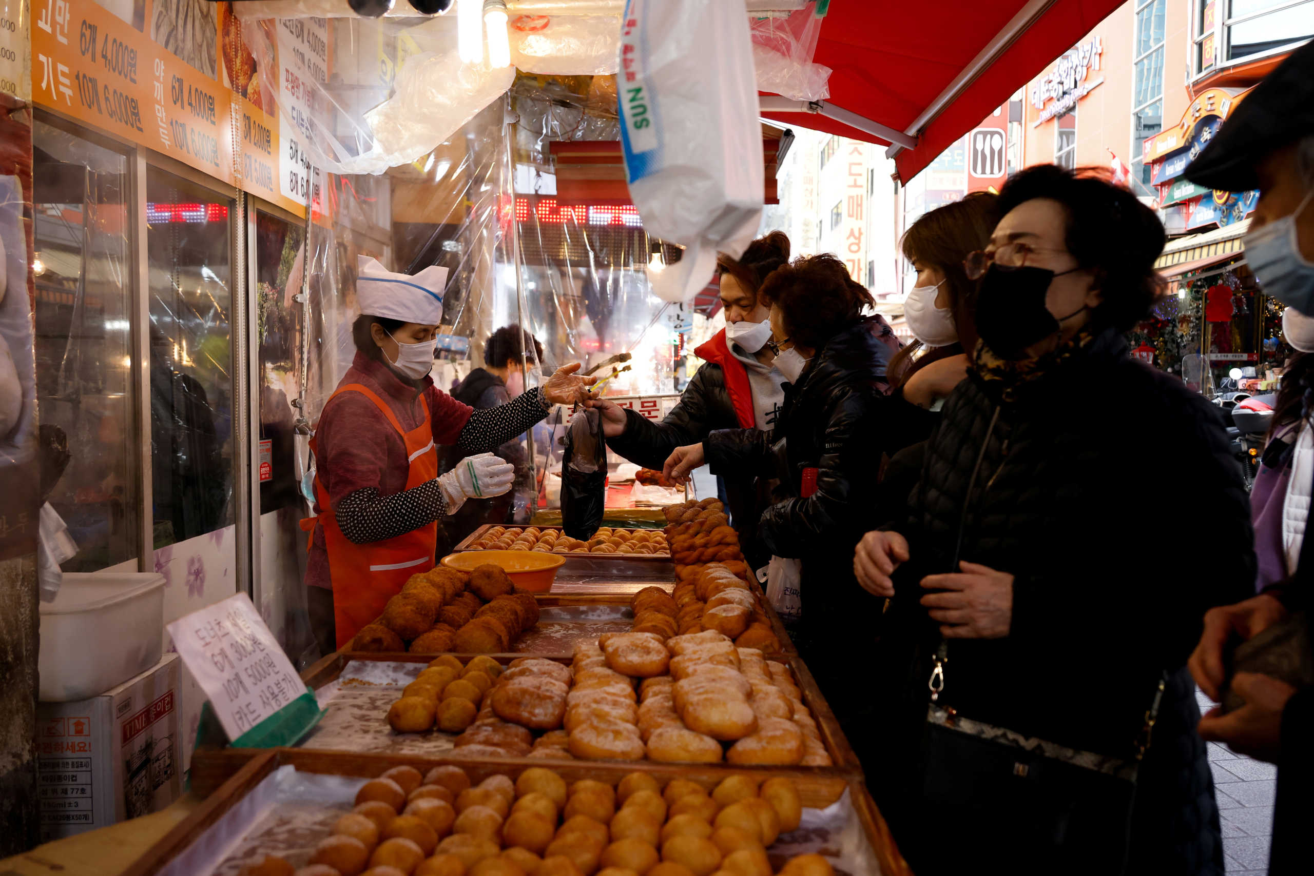 FILE PHOTO: Women buy donuts at a traditional market amid the coronavirus disease (COVID-19) pandemic in Seoul, South Korea, November 26, 2020.    REUTERS