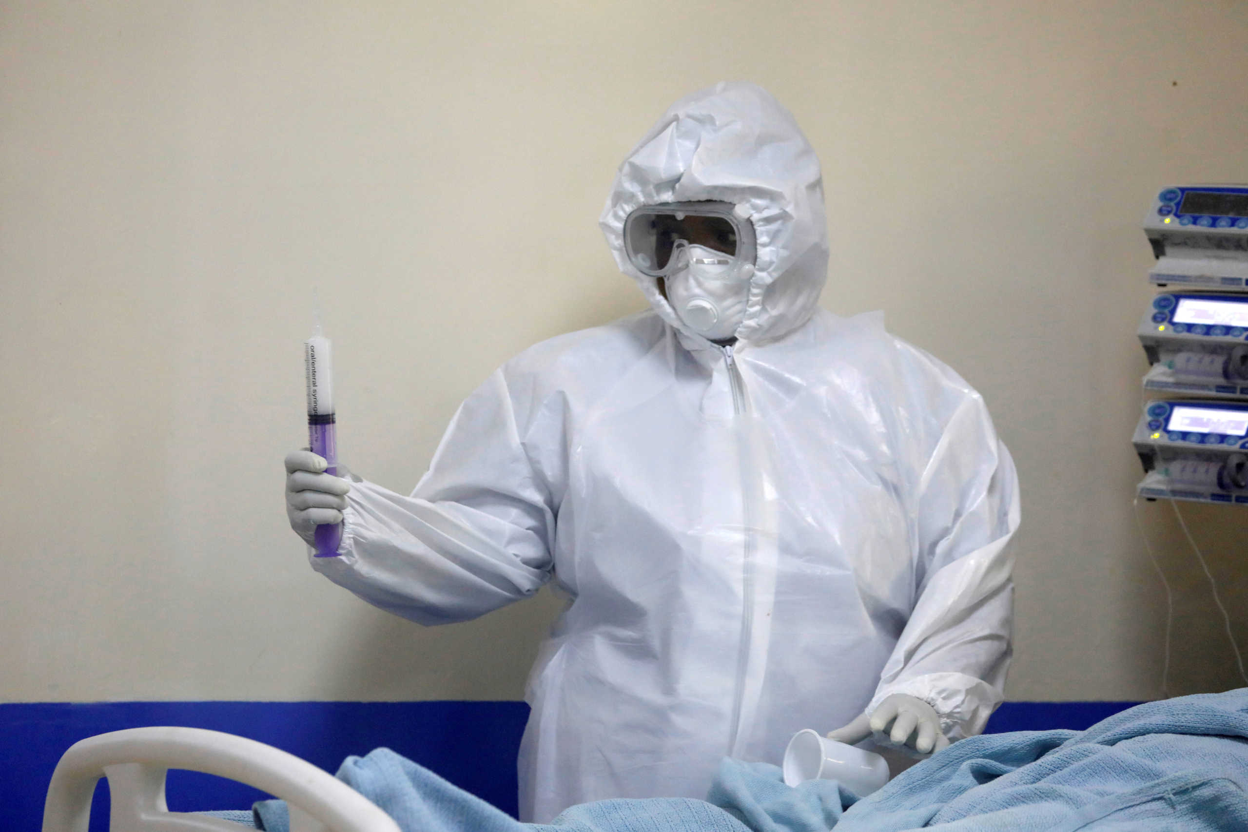 FILE PHOTO: A member of the medical staff dressed in a protective suit holds a syringe as he treats a coronavirus disease patient inside the COVID-19 ICU of Machakos Level 5 Hospital, in Machakos, Kenya October 28, 2020. Picture taken October 28, 2020. REUTERS