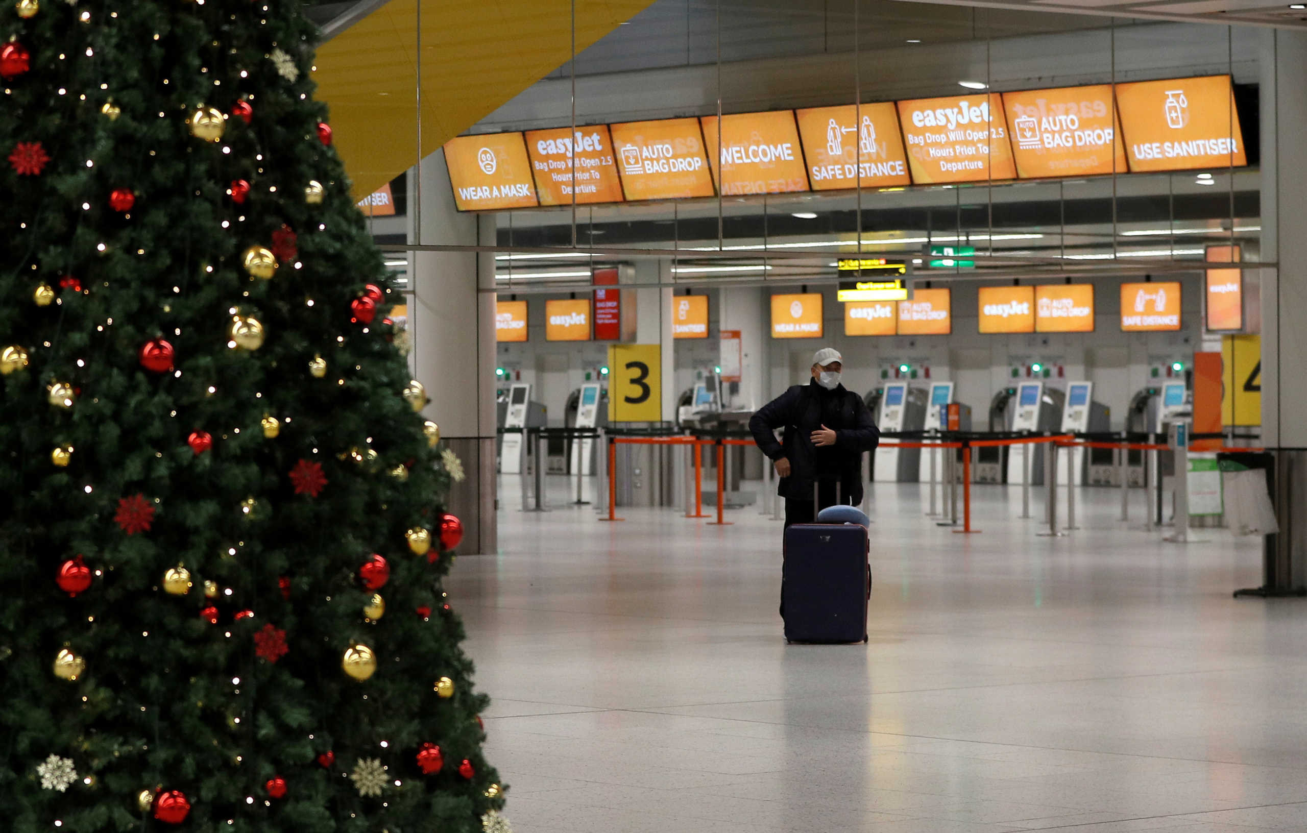FILE PHOTO: A passenger stands in an almost empty check-in area at Gatwick Airport, amid the coronavirus disease (COVID-19) outbreak, in Crawley, Britain, November 27, 2020.  REUTERS