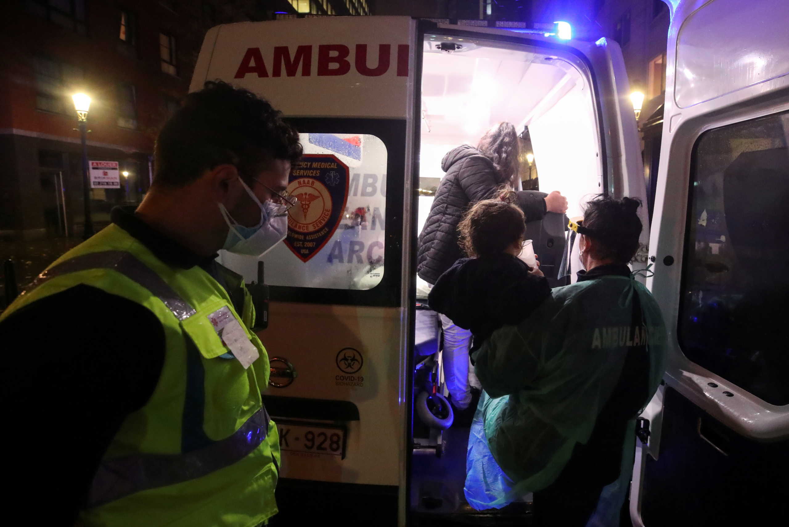 A member of the medical personnel working for NAAB Ambulance wearing personal protective equipment (PPE) carries a one-year-old into an ambulance outside a house for homeless people amid the coronavirus disease (COVID-19) outbreak, in Brussels, Belgium October 28, 2020. REUTERS