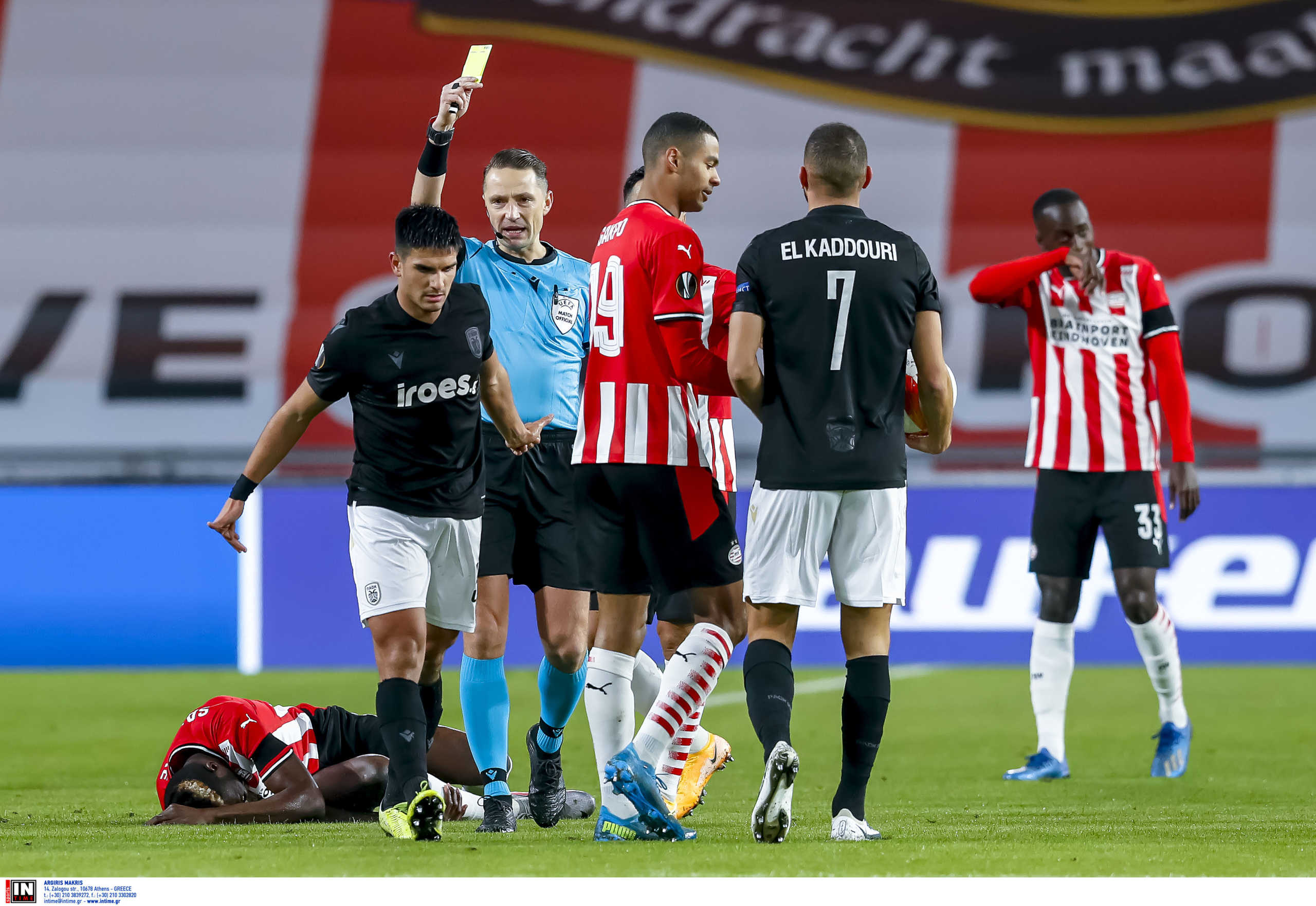 EINDHOVEN - 26-11-2020, Philips stadium. Dutch football, eredivisie, season 2020-2021. UEFA Europa League.  PAOK player Charis Tsiggaras gets a yellow card of Referee Andris Treimanis during the match PSV - PAOK Saloniki.
