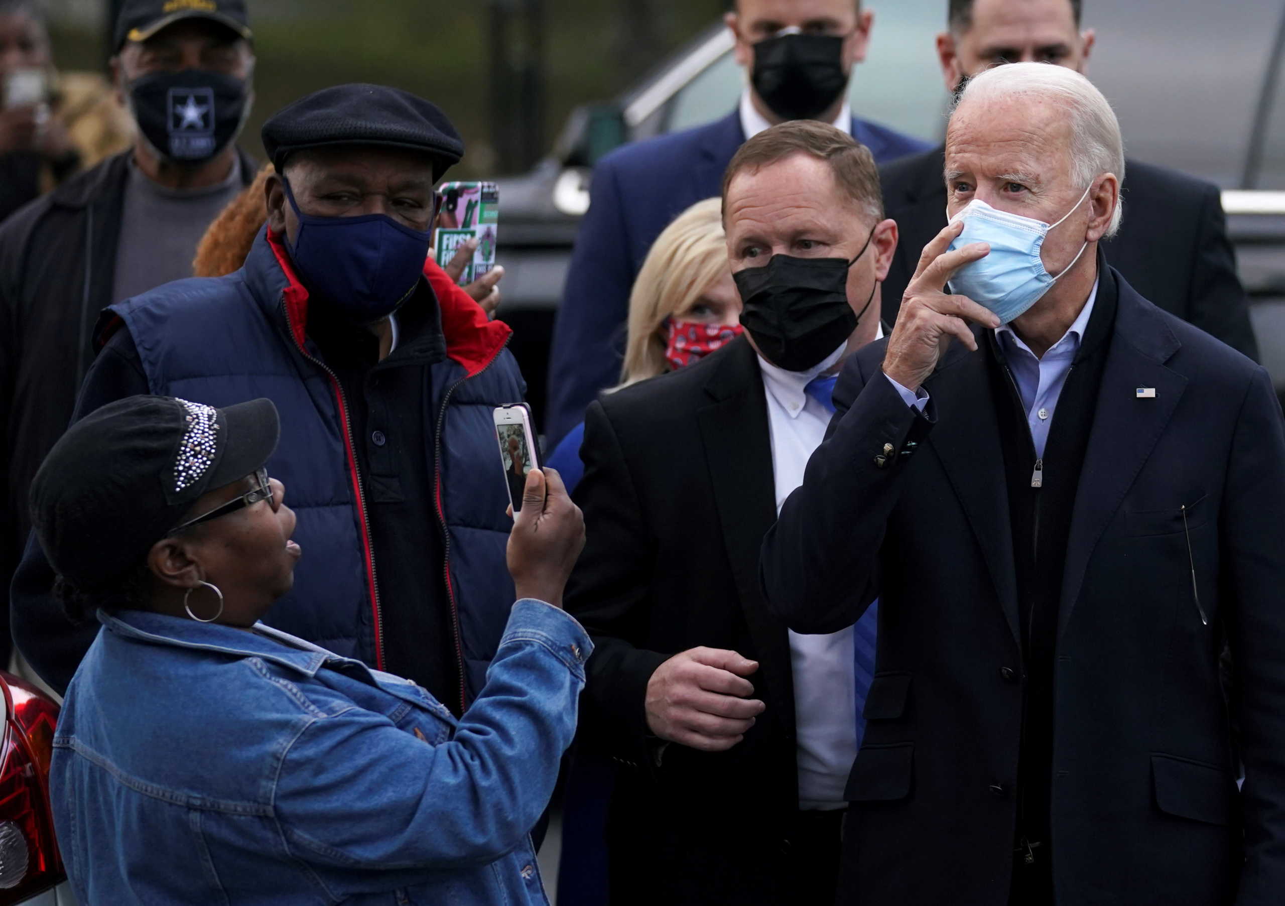 A woman takes a photo of U.S. Democratic presidential nominee Joe Biden as he visits a neighborhood in Wilmington, on Election Day, Delaware, U.S. November 3, 2020. REUTERS