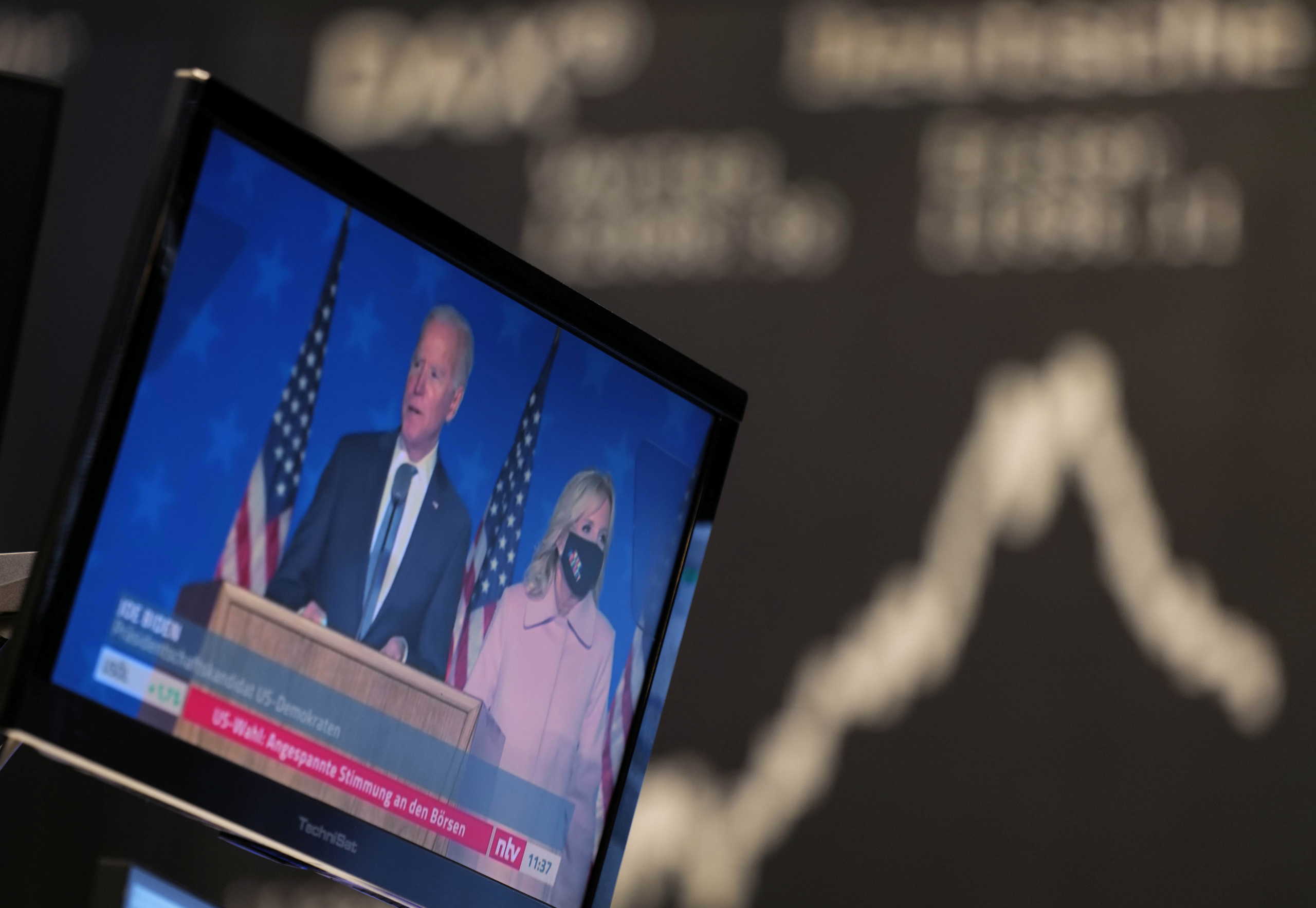 U.S. Democratic presidential nominee and former Vice President Joe Biden is seen on a TV screen as the German share price index DAX reacts to the 2020 U.S. presidential election at the stock exchange in Frankfurt, Germany, November 4, 2020. REUTERS