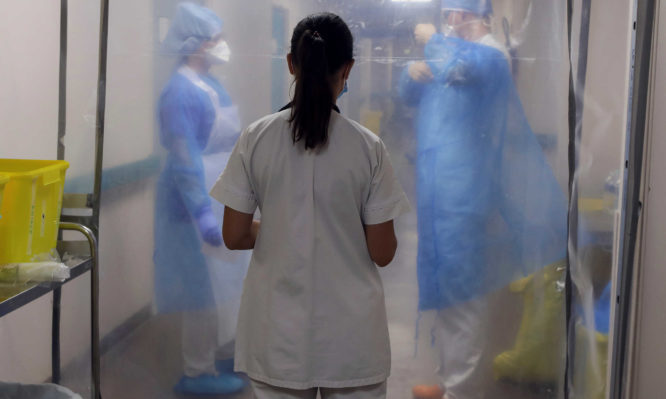 A doctor talks with medical staff wearing protective suits and face masks, at the coronavirus disease (COVID-19) Unit of the military hospital Laveran in Marseille, France, September 18, 2020. REUTERS