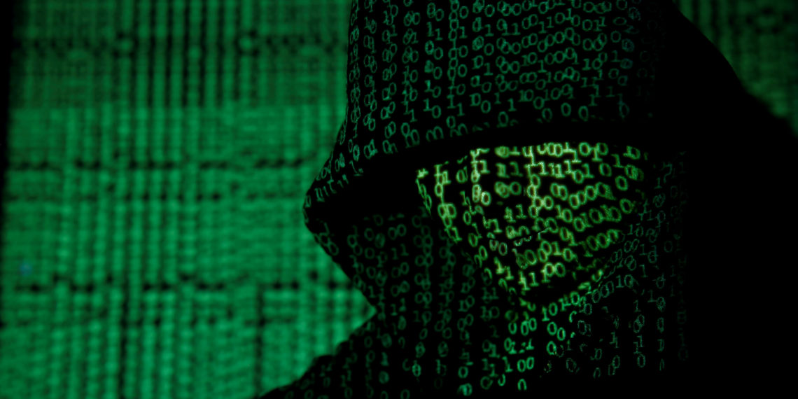 FILE PHOTO: A projection of cyber code on a hooded man is pictured in this illustration picture taken on May 13,  2017. REUTERS