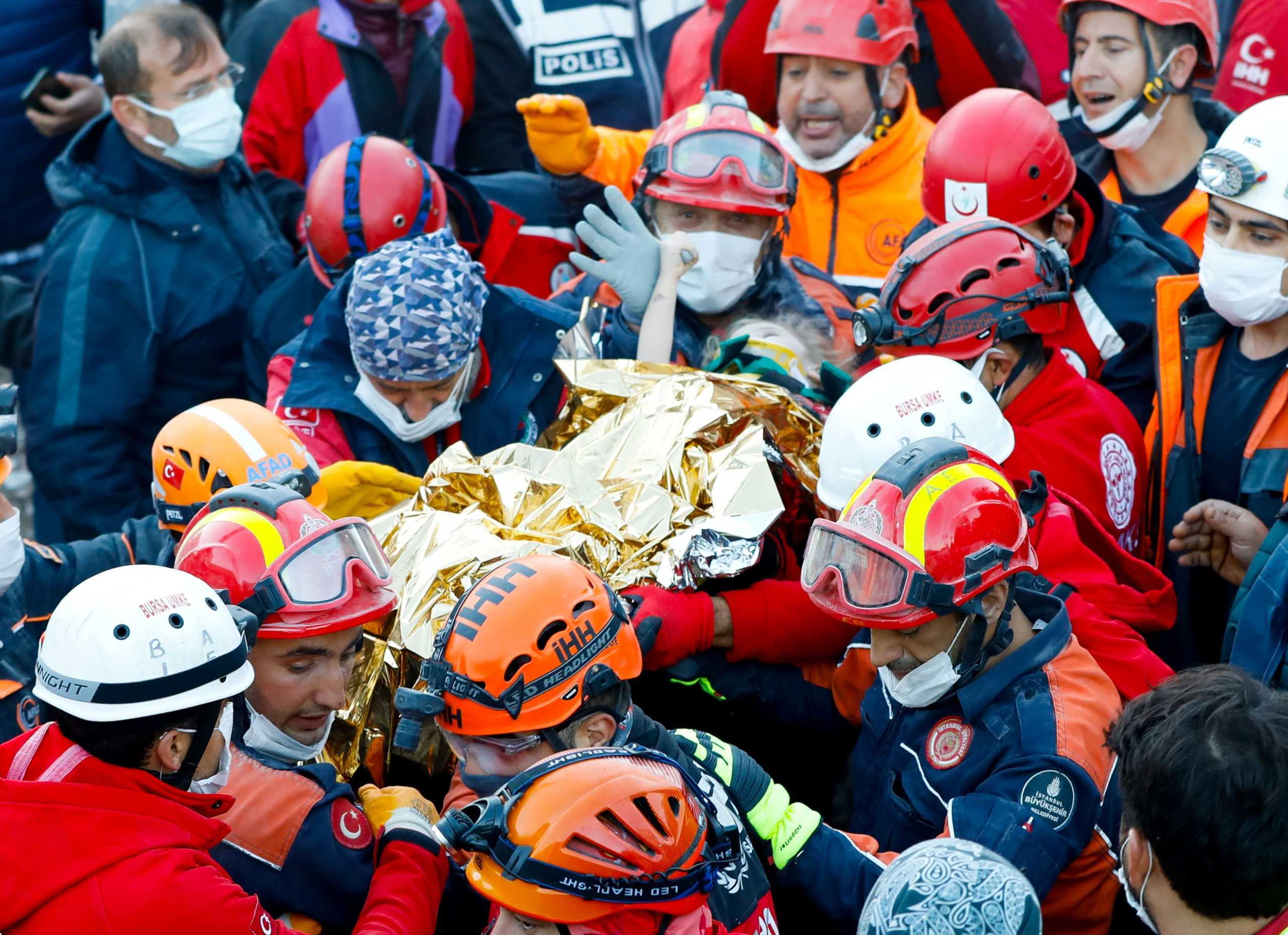 Elif Perincek, a three-year-old survivor, holds the thumb of a rescue worker as she is carried out of a collapsed building after an earthquake in the Aegean port city of Izmir, Turkey November 2, 2020. Istanbul Fire Department
