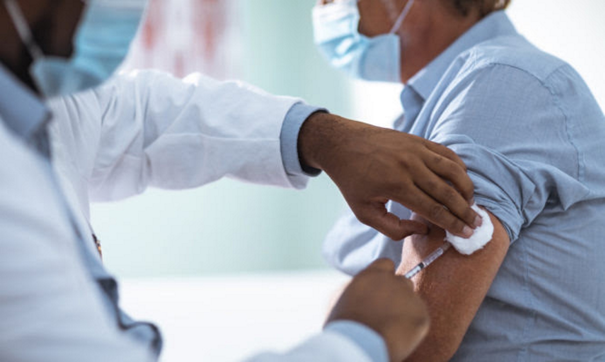 Close up of a mature man taking a vaccine in his doctors office