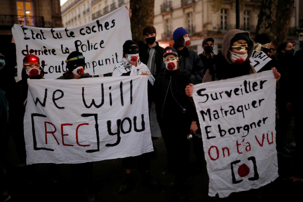 FILE PHOTO: Masked rights activists and journalists protest as the French parliament debates a draft law that would make it a crime in some circumstances to circulate an image of a police officer's face, in Nantes, France, November 17, 2020.  REUTERS
