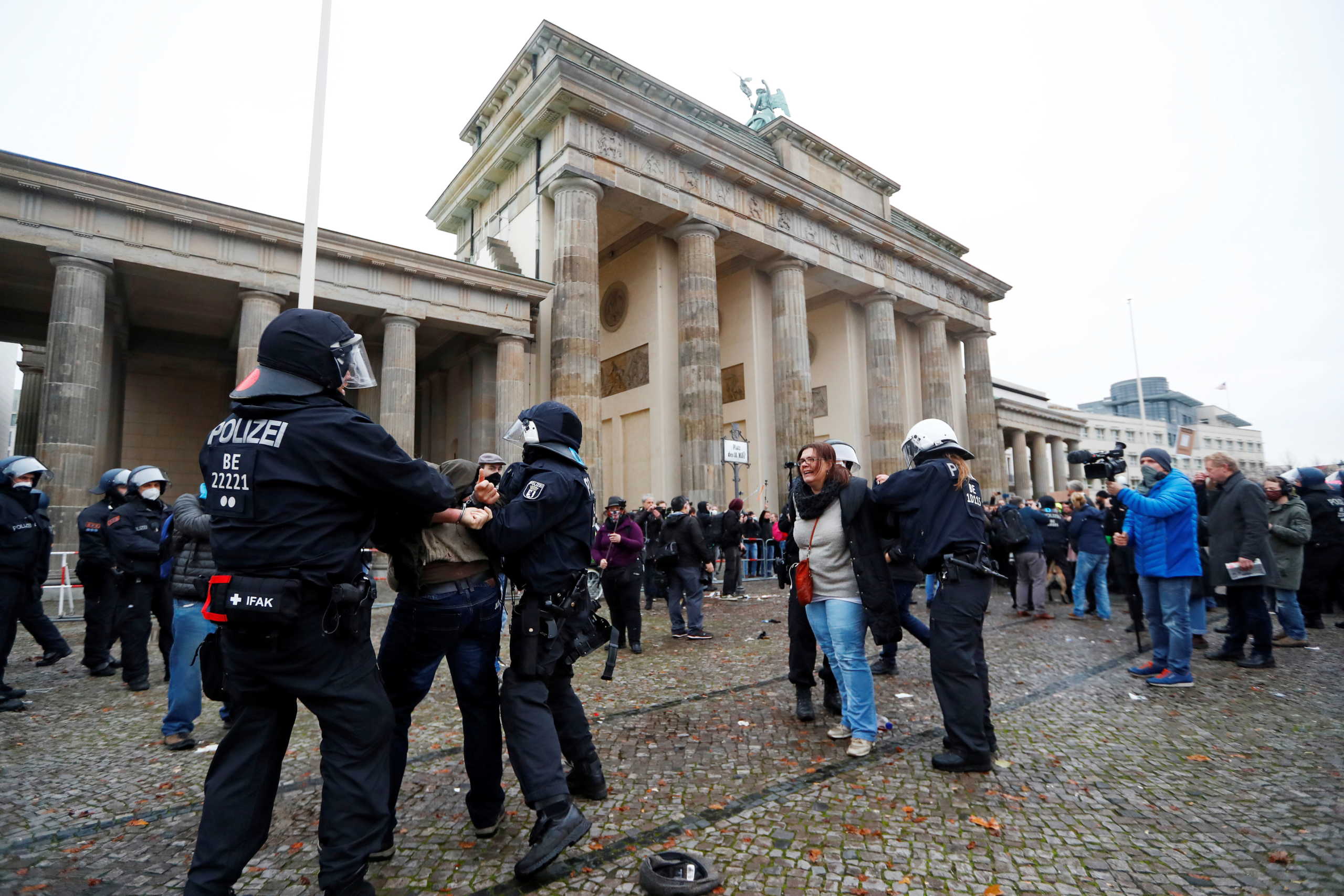 Demonstrators are detained by police officers during a protest against the government's coronavirus disease (COVID-19) restrictions, next to the Brandenburger Gate in Berlin, November, 18, 2020. REUTERS