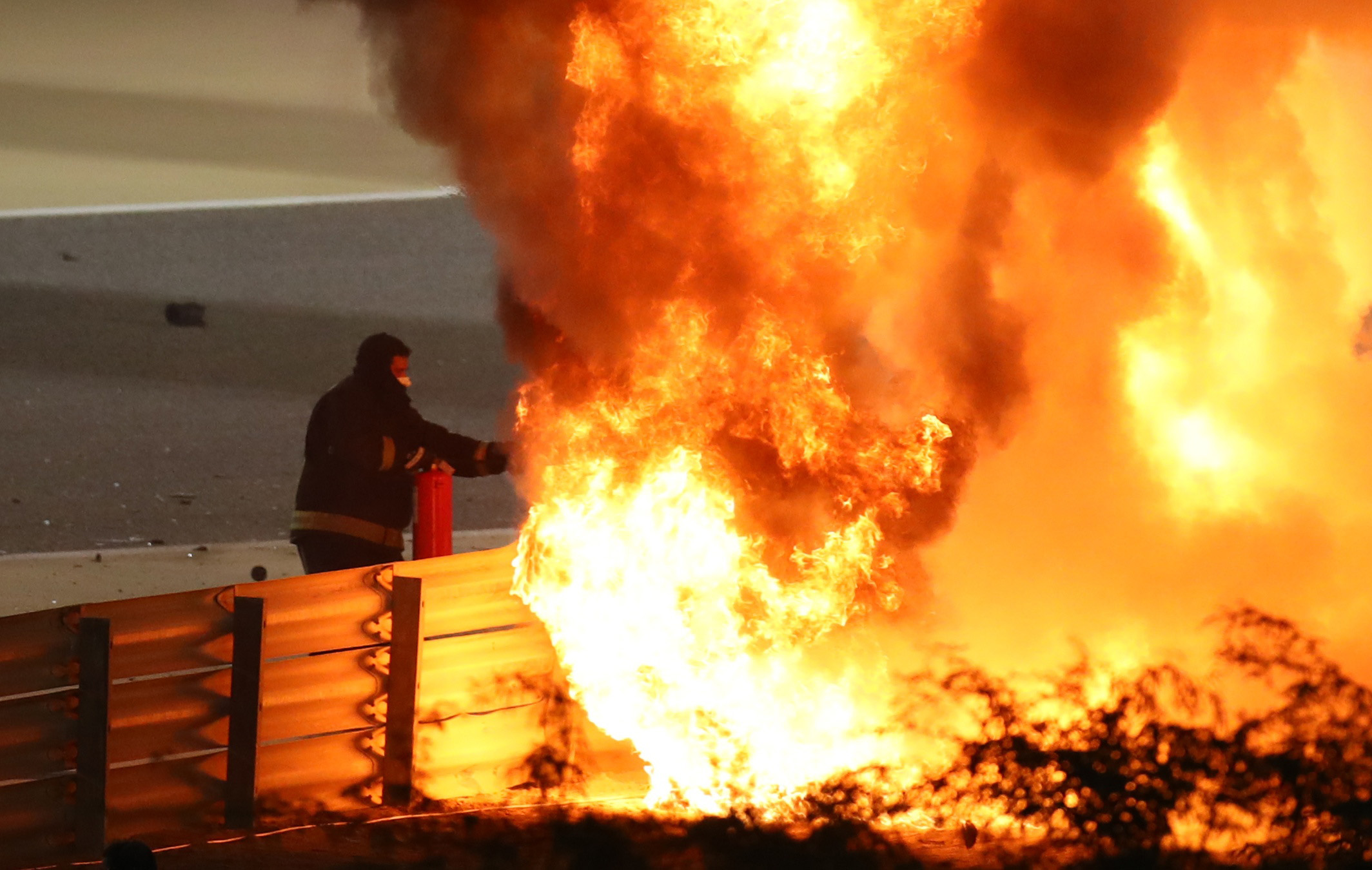 Formula One F1 - Bahrain Grand Prix - Bahrain International Circuit, Sakhir, Bahrain - November 29, 2020 A Steward attempts to extinguish flames at the crash scene after Haas' Romain Grosjean crashed out at the start of the race Pool via REUTERS