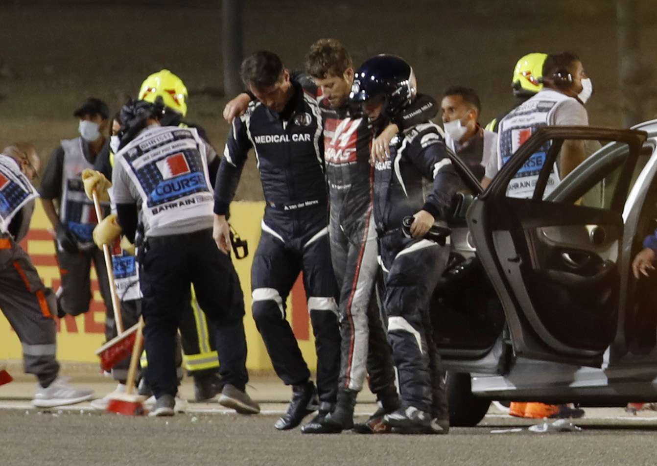 Formula One F1 - Bahrain Grand Prix - Bahrain International Circuit, Sakhir, Bahrain - November 29, 2020 Haas' Romain Grosjean walks away from the crash scene with the help of medical officers after crashing out of the race Pool via REUTERS