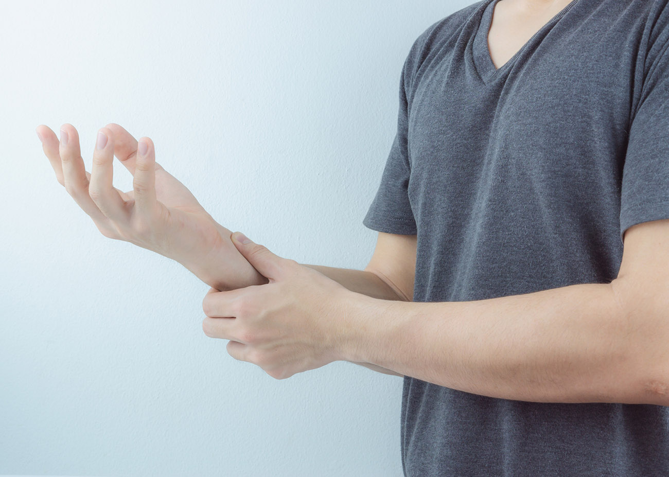 Closeup man holds his wrist pain on white background. Health care and medical concept.