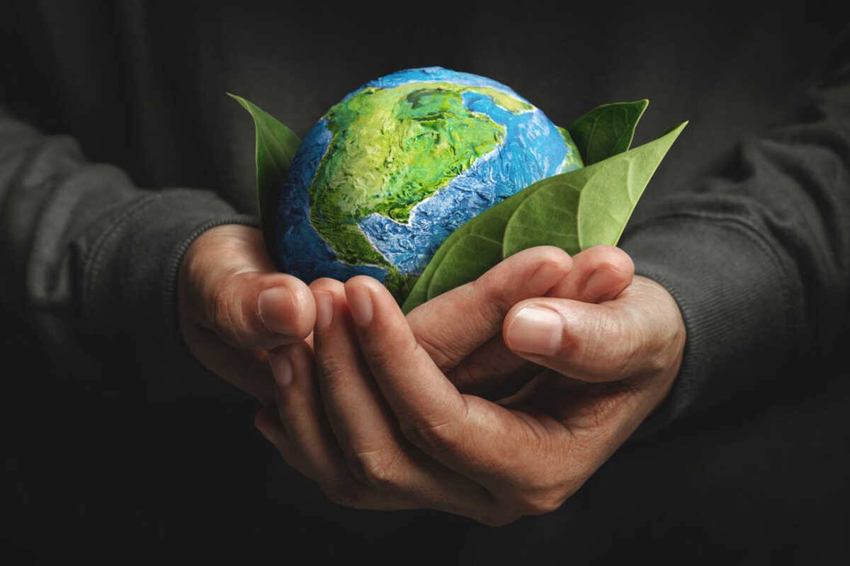 World Earth Day Concept. Green Energy, Renewable and Sustainable Resources. Environmental and Ecology Care. Hand Embracing Green Leaf and Handmade Globe