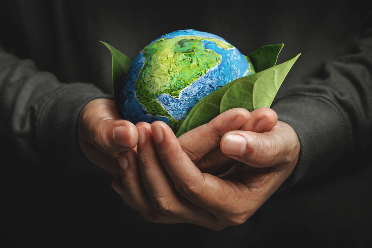 World Earth Day Concept. Green Energy, Renewable and Sustainable Resources. Environmental and Ecology Care. Hand Embracing Green Leaf and Handmade Globe