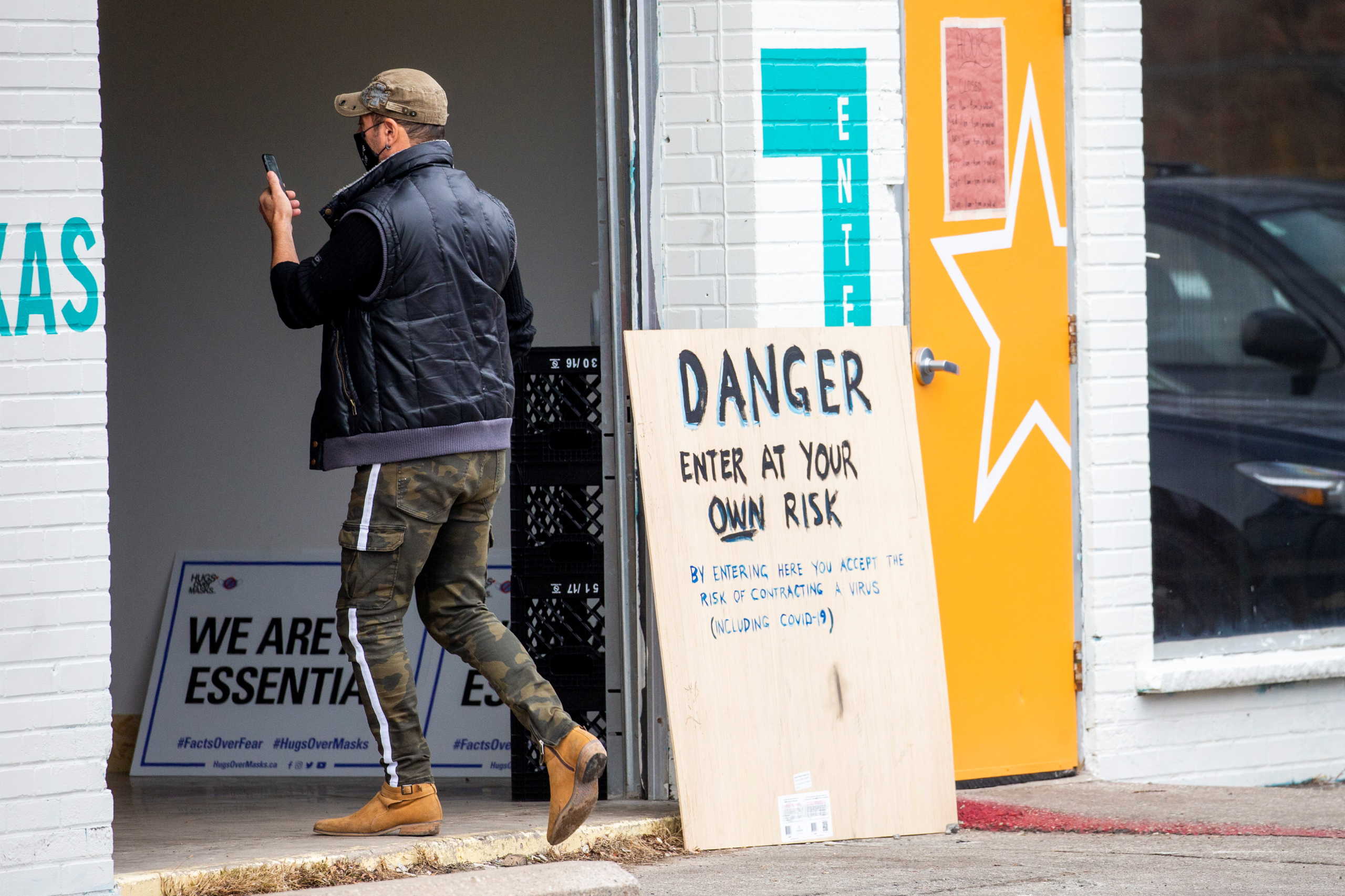 A man enters Adamson Barbecue, which opened for indoor dining despite a reintroduction of coronavirus disease (COVID-19) restrictions in the Etobicoke suburb of Toronto, Ontario, Canada November 24, 2020.  REUTERS