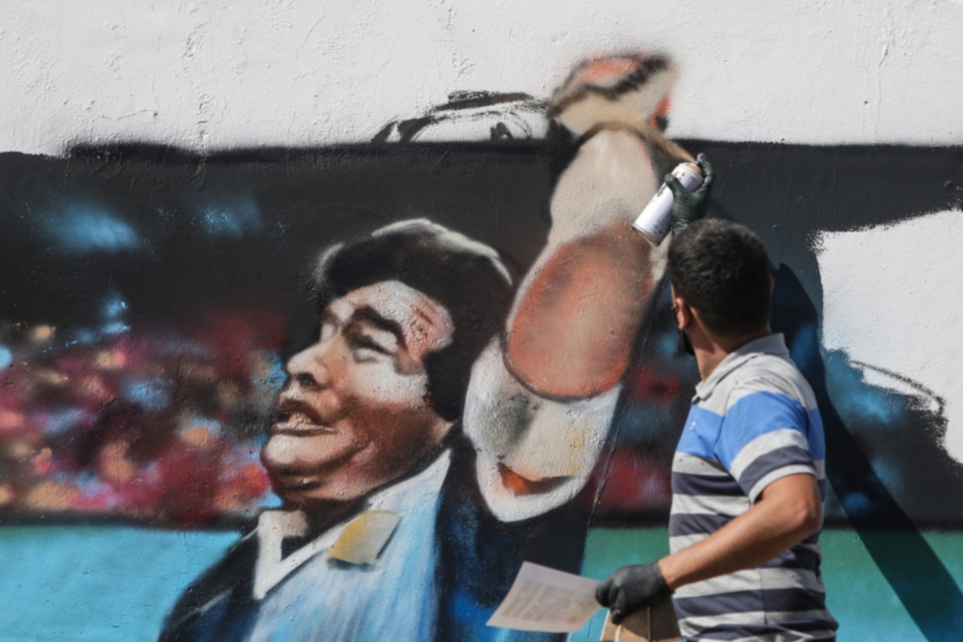 epa08787004 A man paints a mural with the image of former Argentinian soccer player Diego Maradona at Villa Palito neigborhood in La Matanza municipality, Buenos Aires province, Argentina, 30 October 2020. Maradona turns 60 on 30 October.  EPA