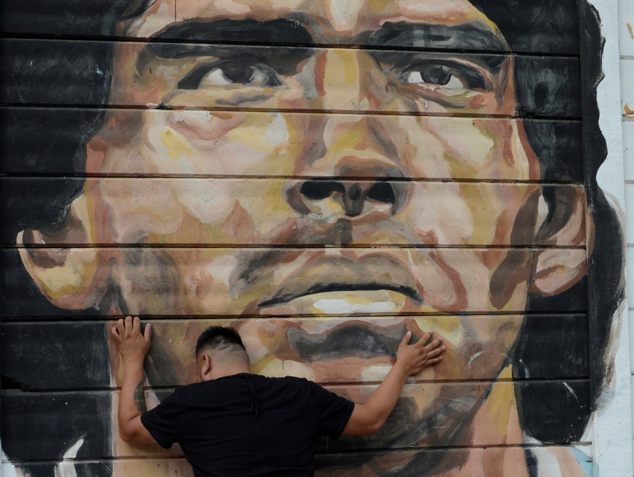 A fan reacts while mourning the death of soccer legend Diego Armando Maradona, outside the Diego Armando Maradona stadium, in Buenos Aires, Argentina November 25, 2020.  REUTERS