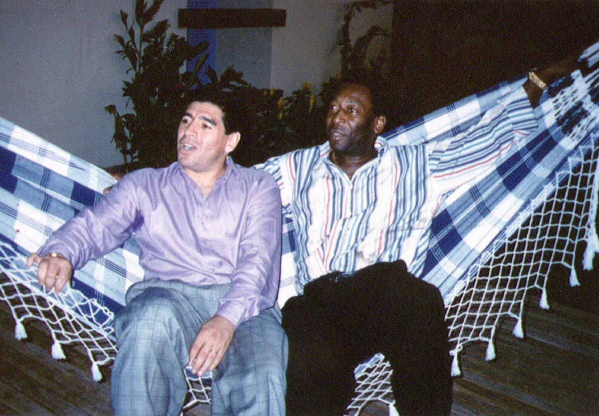 FILE PHOTO: Soccer legends Diego Maradona (L) and Pele rest on a hammock during a reception in Rio de Janeiro, May 14, 1995.  REUTERS