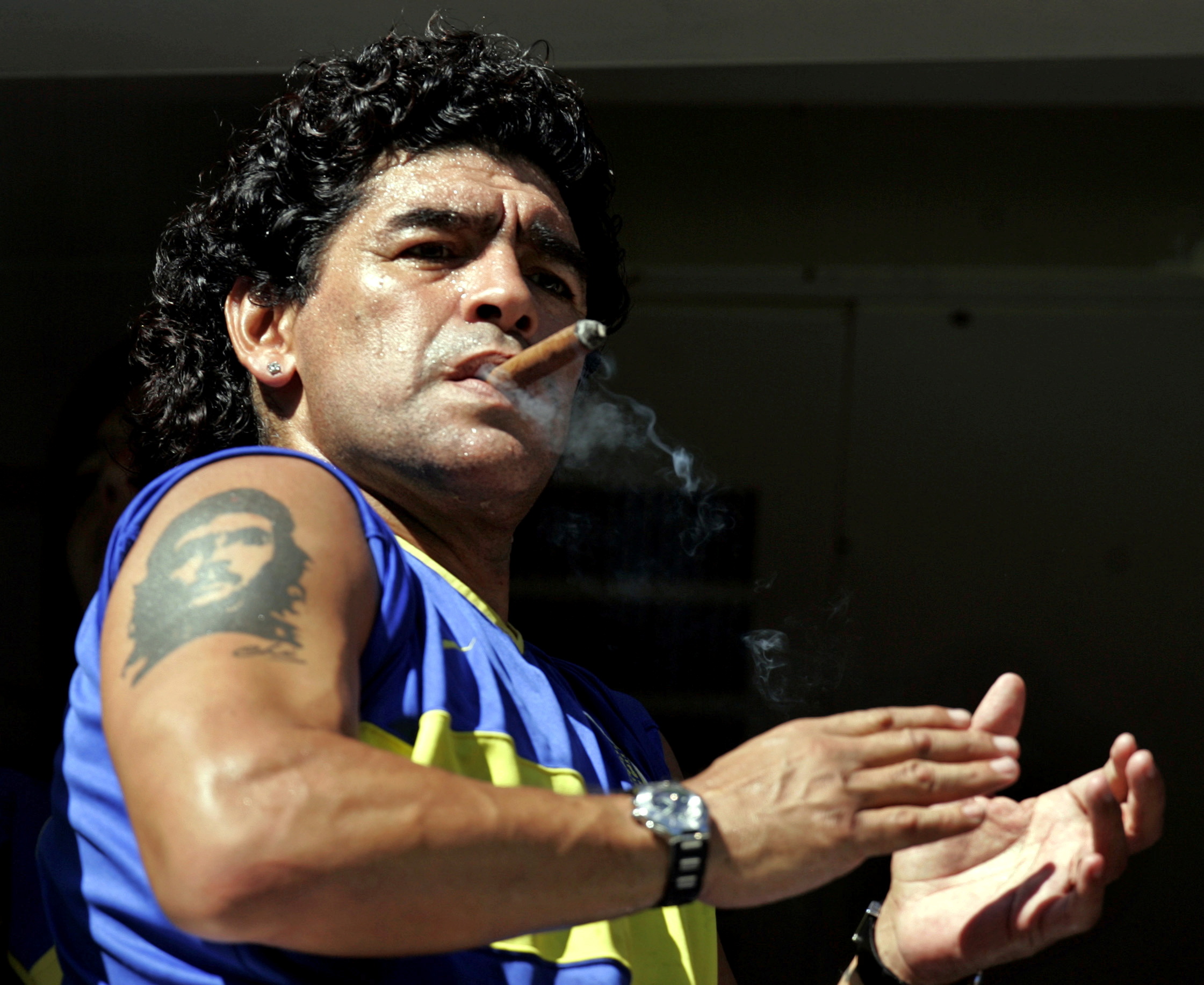 FILE PHOTO: Former Argentine soccer star Diego Maradona smokes a cigar before the start of the Argentine First Division soccer match between Boca Juniors and San Lorenzo de Almagro at La Bombonera stadium in Buenos Aires February 19, 2006. REUTERS