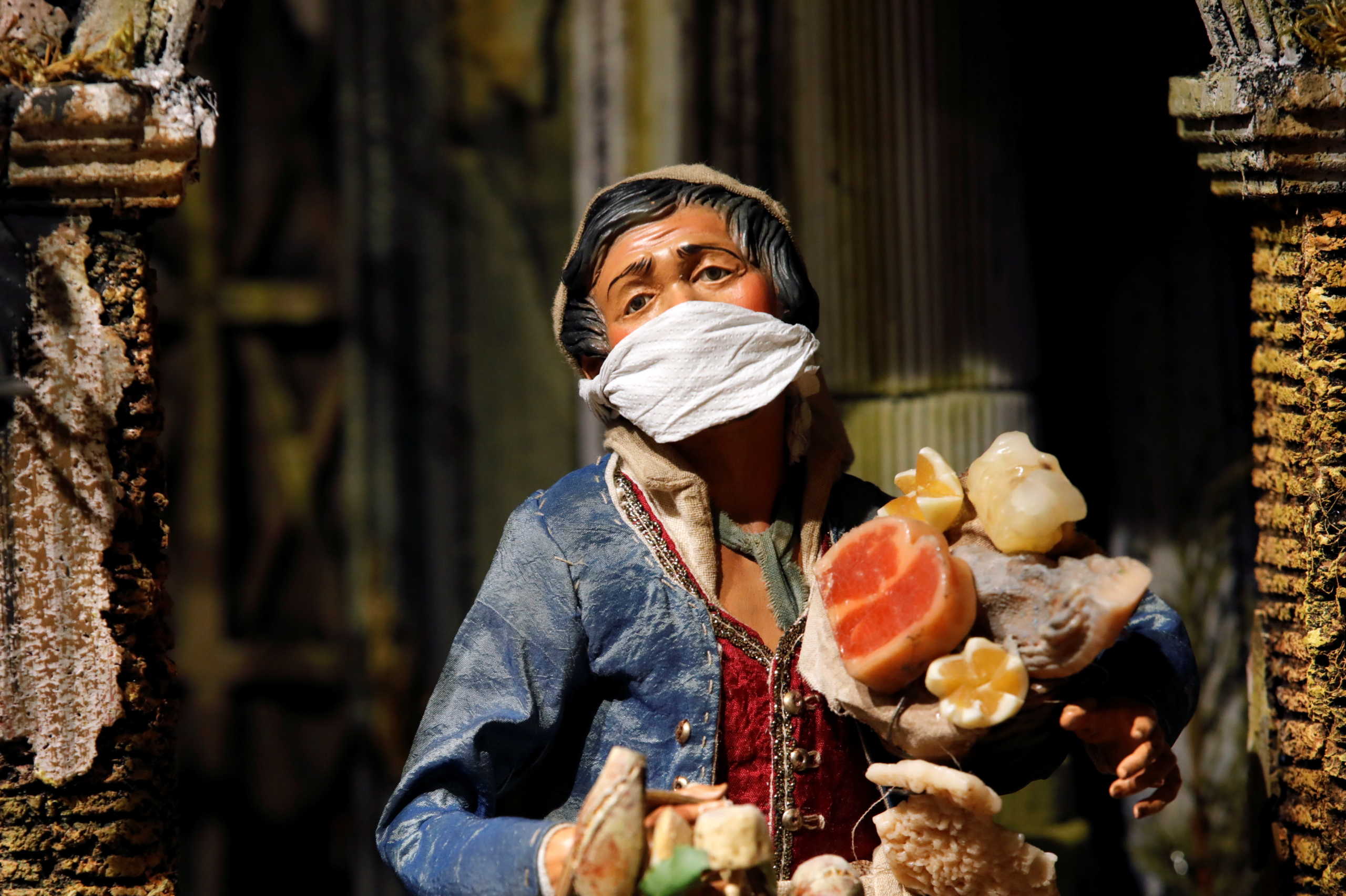 A figurine wearing a mask is pictured on display at a shop on via San Gregorio Armeno, the famous street in Naples dedicated to producing nativity figurines, which this year has a different look due to the coronavirus disease (COVID-19), in Naples, Italy, November 13, 2020. REUTERS