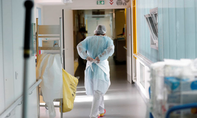 A doctor, wearing a protective mask and a protective suit, works in a pulmonology unit at the hospital in Vannes where patients suffering from the coronavirus disease (COVID-19) are treated, France, October 12, 2020. REUTERS