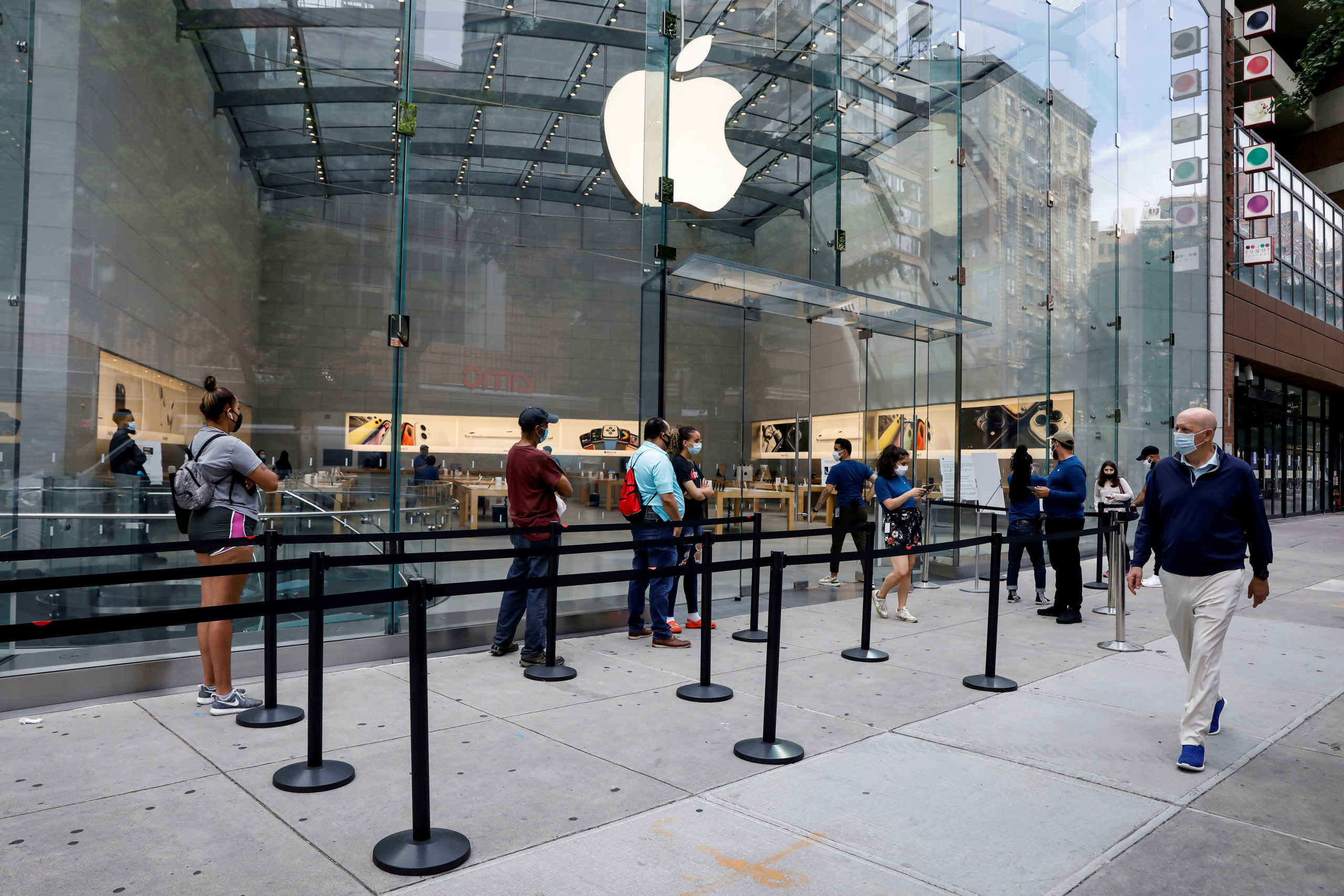 FILE PHOTO: Customers distance before entering an Apple Store during phase one of reopening after the COVID-19 lockdown in New York City, New York, U.S. June 17, 2020. REUTERS