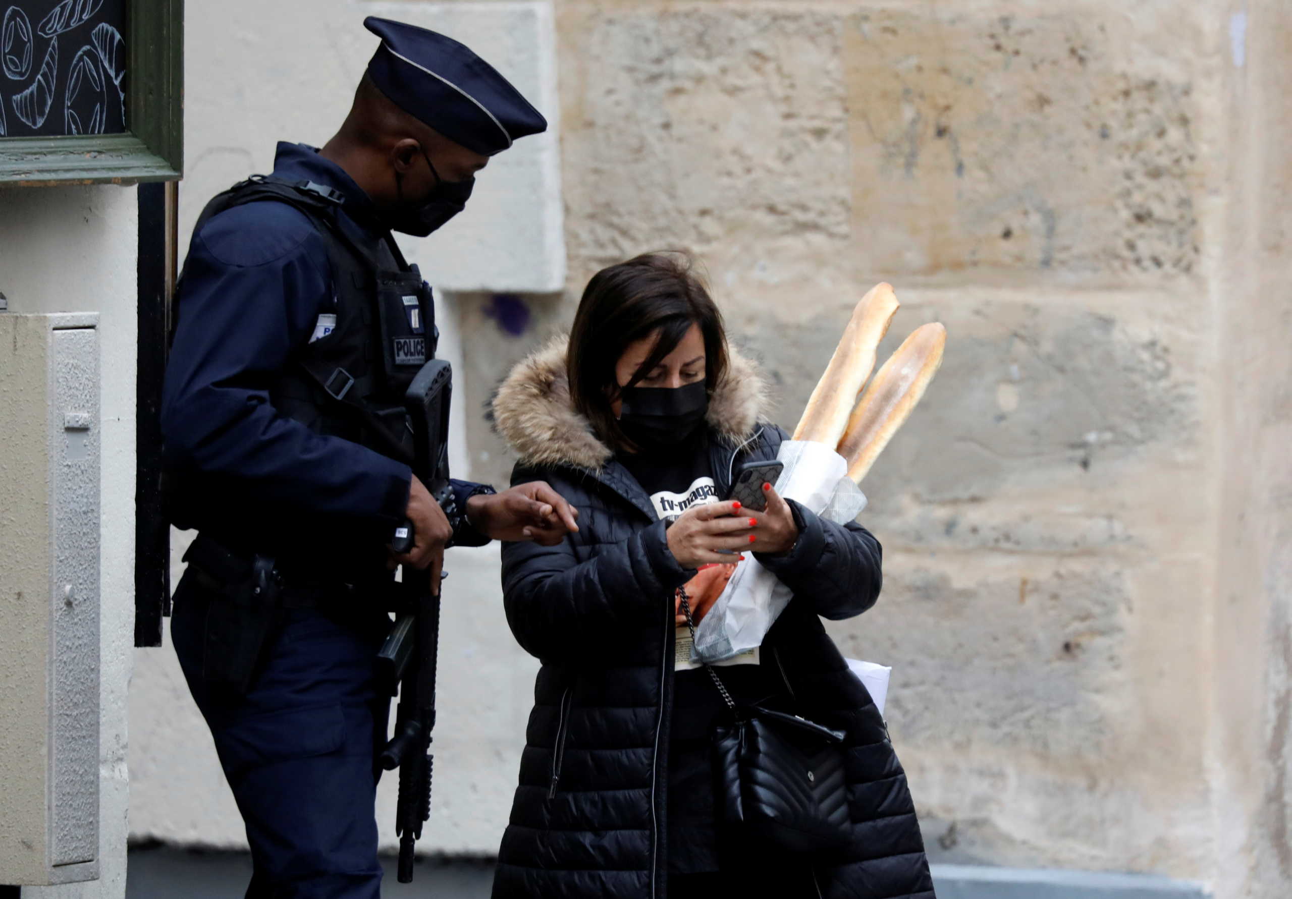 A policeman controls a woman in a street in Paris on the first day of the second national lockdown as part of the COVID-19 measures to fight a second wave of the coronavirus disease (COVID-19), France, October 30, 2020. REUTERS