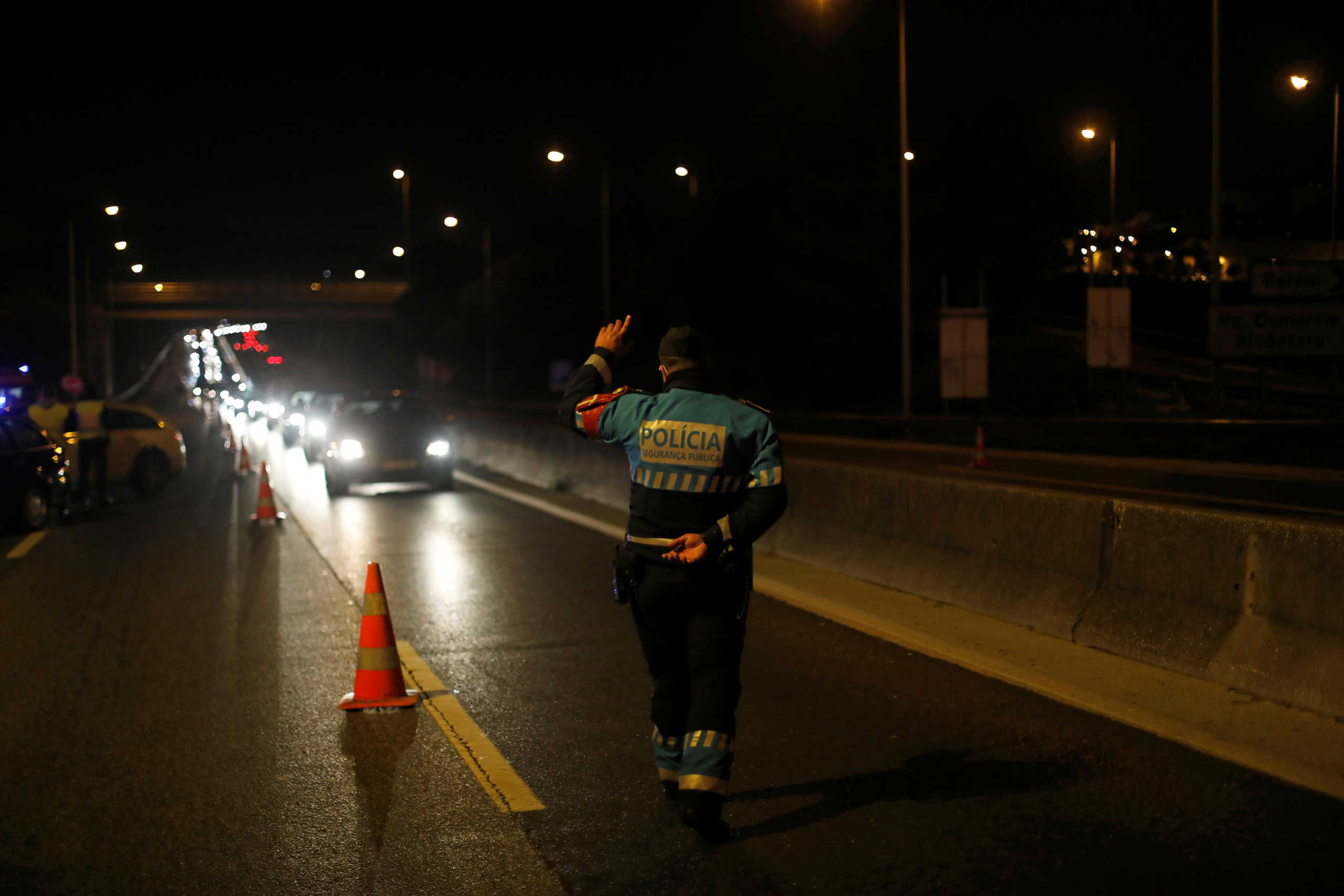A police officer stands guard at a checkpoint to control the movement between different municipalities during the coronavirus disease (COVID-19) outbreak, in Lisbon, Portugal October 30, 2020.  REUTERS