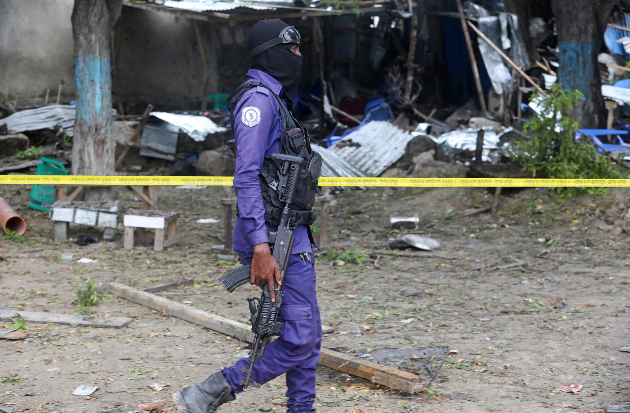 A Somali policeman secures the scene of a suicide explosion at a restaurant near a police academy, in Mogadishu, Somalia November 17, 2020. REUTERS