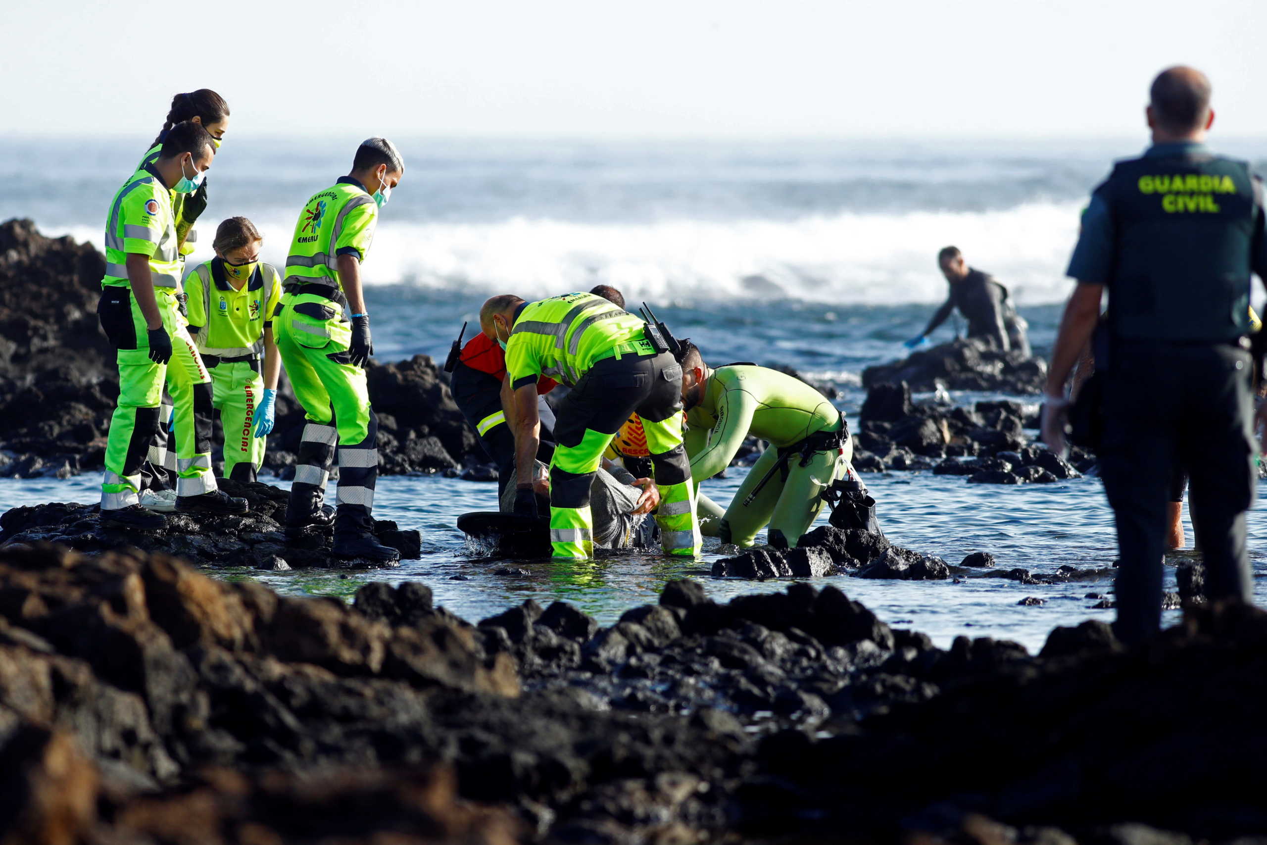 SENSITIVE MATERIAL. THIS IMAGE MAY OFFEND OR DISTURB    Rescue workers get out from water the body of a dead person after a boat with 35 migrants from the Maghreb region capsized in the beach of Orzola, in the Canary Island of Lanzarote, Spain November 25, 2020. REUTERS