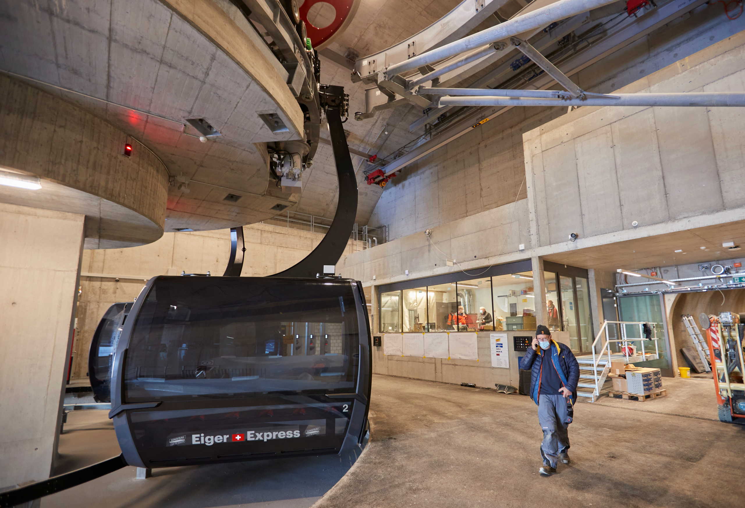 A staff stands in front of a gondola of the Eiger Express in the V-cableway EIgergletscher station of the Jungfrau Railways, a 470 million CHF investment connecting Grindelwald to Maennlichen and Eigergletscher with 2 lifts, during last testings before its opening on December 4, amid the coronavirus disease (COVID-19) outbreak, in the ski resort of Grindelwald, Switzerland November 23, 2020. REUTERS
