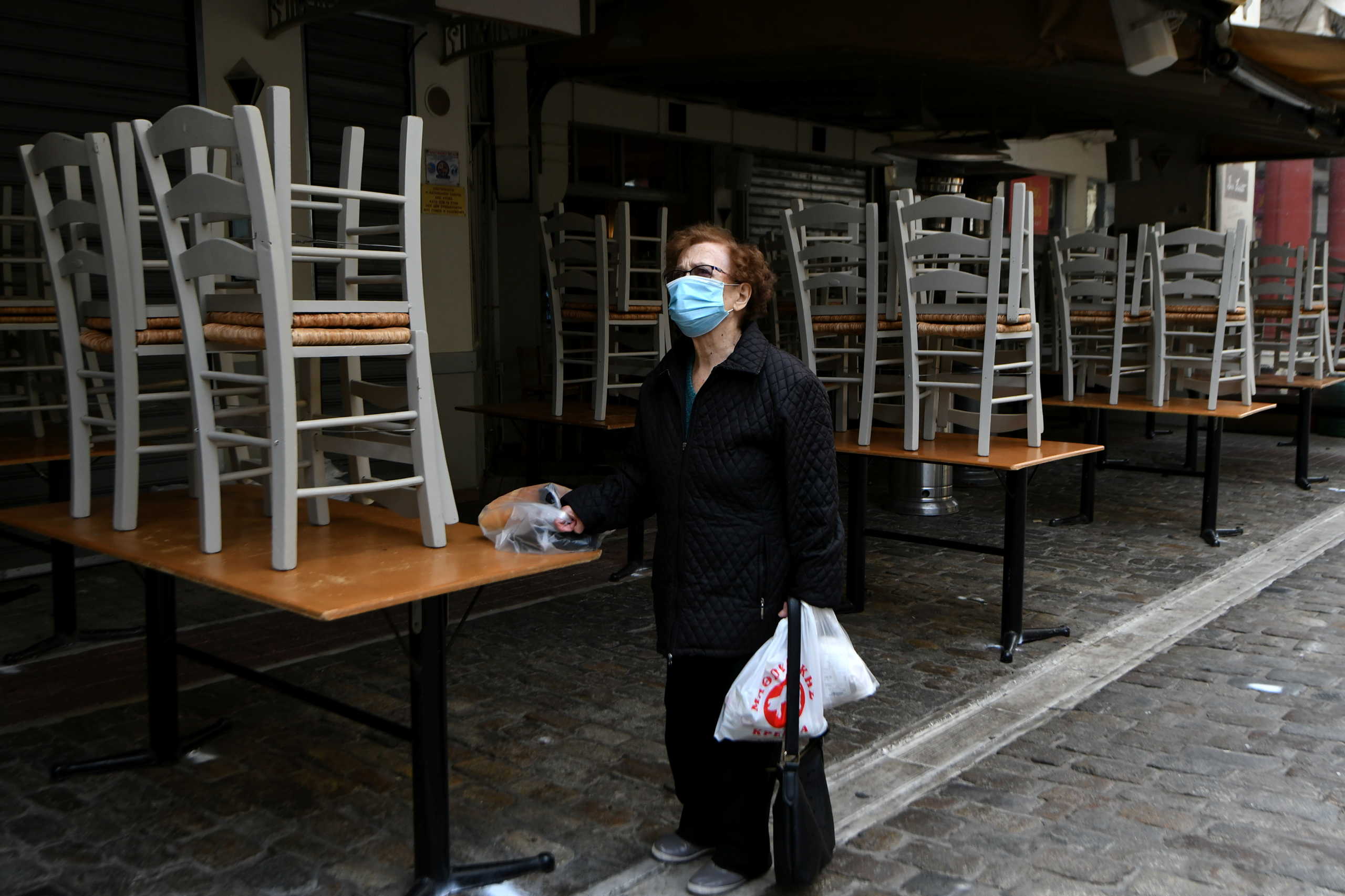 A woman stands outside a closed restaurant, amid the coronavirus disease (COVID-19) pandemic, in Thessaloniki, Greece, October 30, 2020. REUTERS