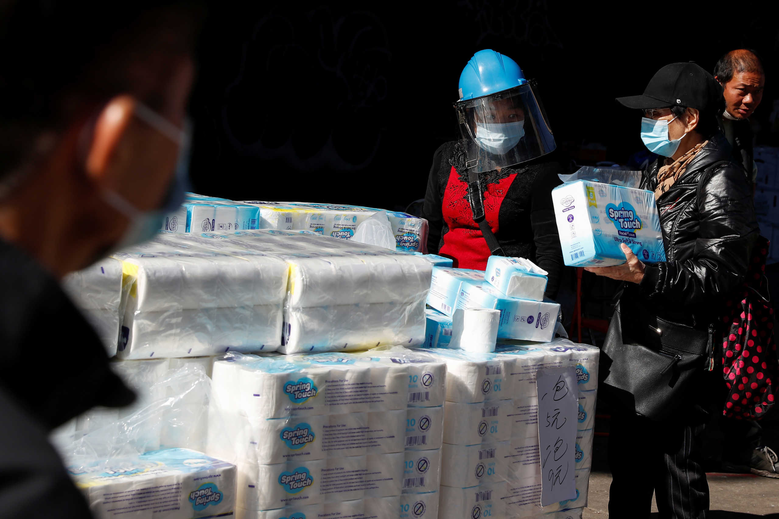 A woman wearing a protective face mask shield sells toilet paper next to sidewalk vendors as the spread of coronavirus disease (COVID-19) continues, in the Chinatown section of New York City, U.S., October 14, 2020. REUTERS