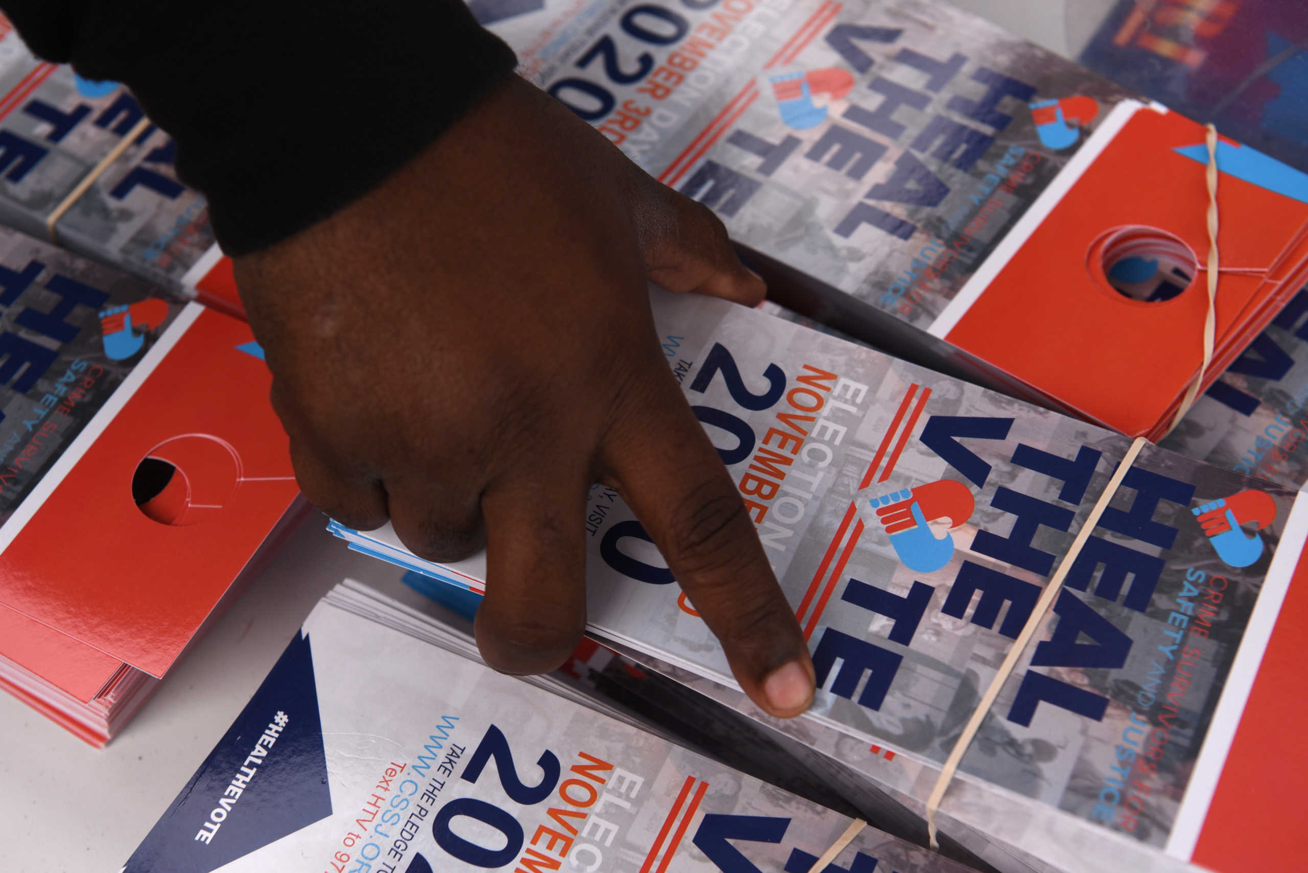 A man grabs flyers to hang on doorhandles at an event hosted by the NAACP to encourage community members to vote in the upcoming presidential election in Houston, Texas, U.S., October 24, 2020. Picture taken October 24, 2020.   REUTERS