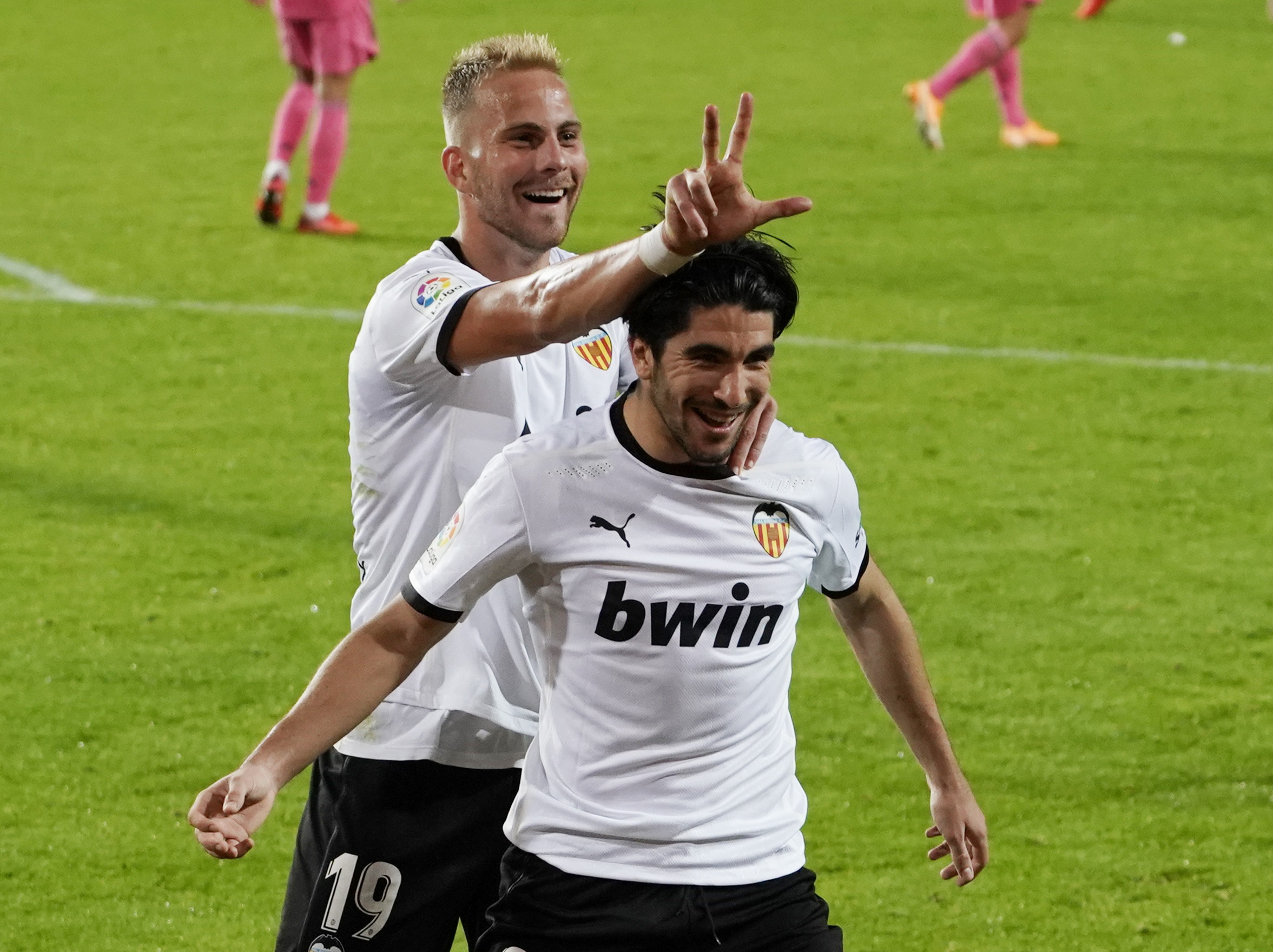 Soccer Football - La Liga Santander - Valencia v Real Madrid - Mestalla, Valencia, Spain - November 8, 2020 Valencia's Carlos Soler celebrates scoring their fourth goal and completing his hat-trick with Uros Racic REUTERS
