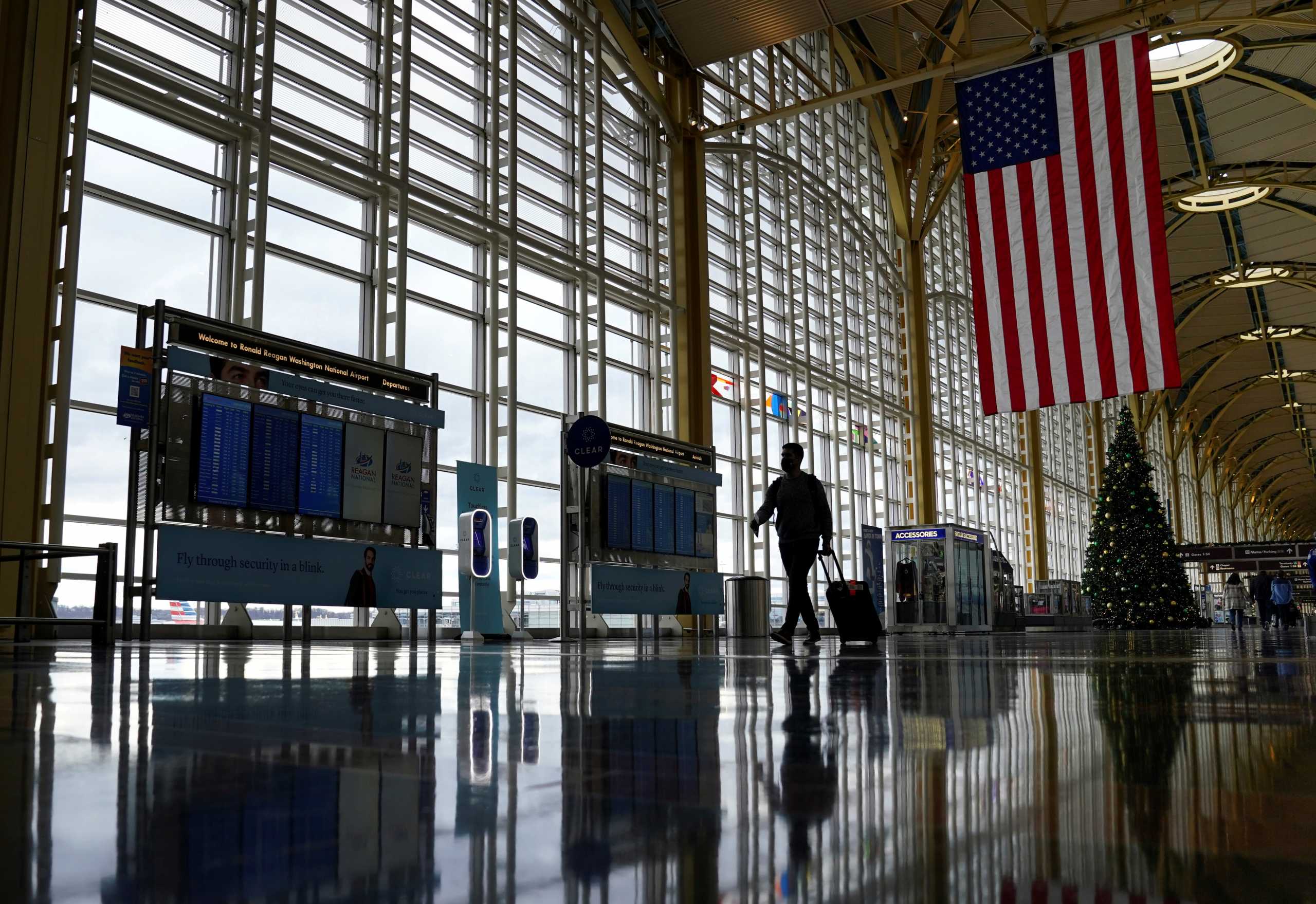 FILE PHOTO: A traveler walks past a Christmas tree as he makes his way through the Ronald Reagan Washington National Airport, in Arlington, Virginia, U.S., December 22, 2020.  REUTERS
