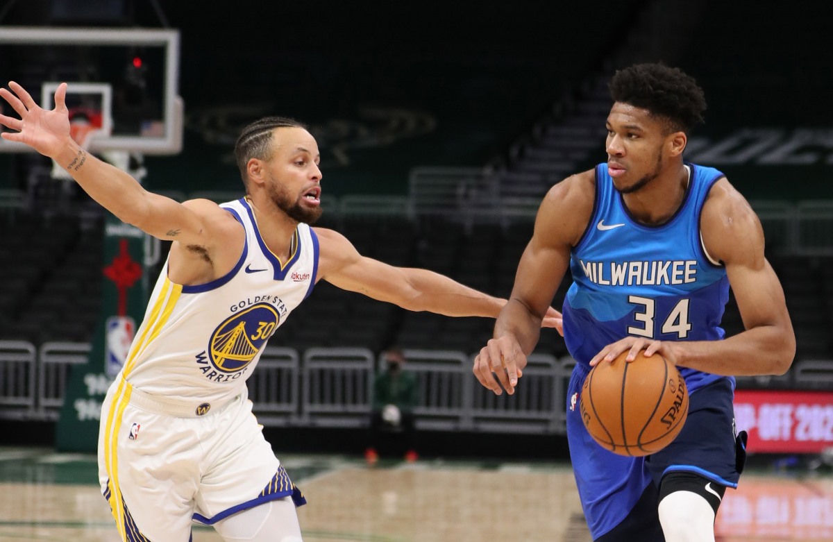 Dec 25, 2020; Milwaukee, WI, USA; Milwaukee Bucks forward Giannis Antetokounmpo (34) dribbles the ball against Golden State Warriors guard Stephen Curry (30) during a NBA game at the Bradley Center. Mandatory Credit: Nick Monroe