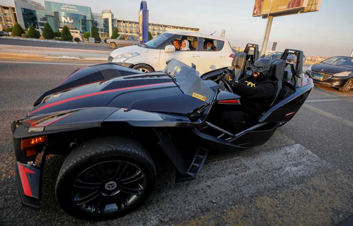 Bassem Raaof, 28, dressed in a Batman costume, drives his "Batmobile" replica around his neighbourhood handing out face masks to residents during Christmas season, amid the coronavirus disease (COVID-19) pandemic in Cairo, Egypt December 17, 2020. Picture taken December 17, 2020. REUTERS