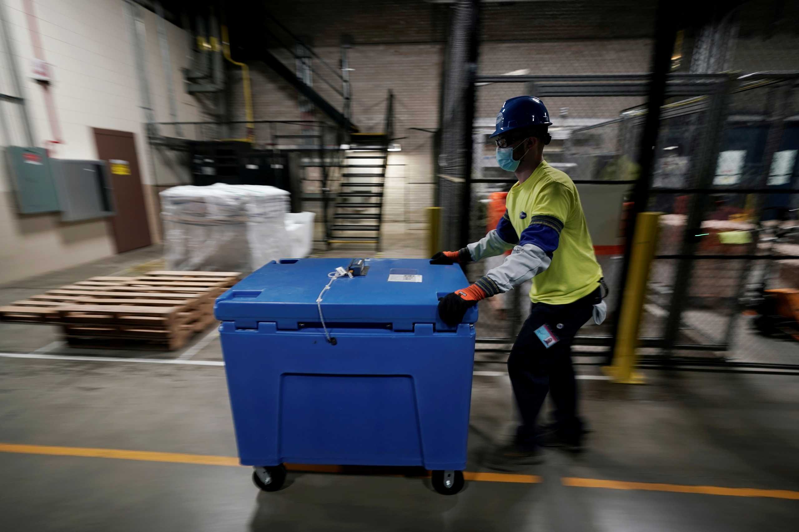 A man pushes a box containing the Pfizer-BioNTech COVID-19 vaccine prepared to be shipped at the Pfizer Global Supply Kalamazoo manufacturing plant in Portage, Michigan, U.S., December 13, 2020.  Morry Gash