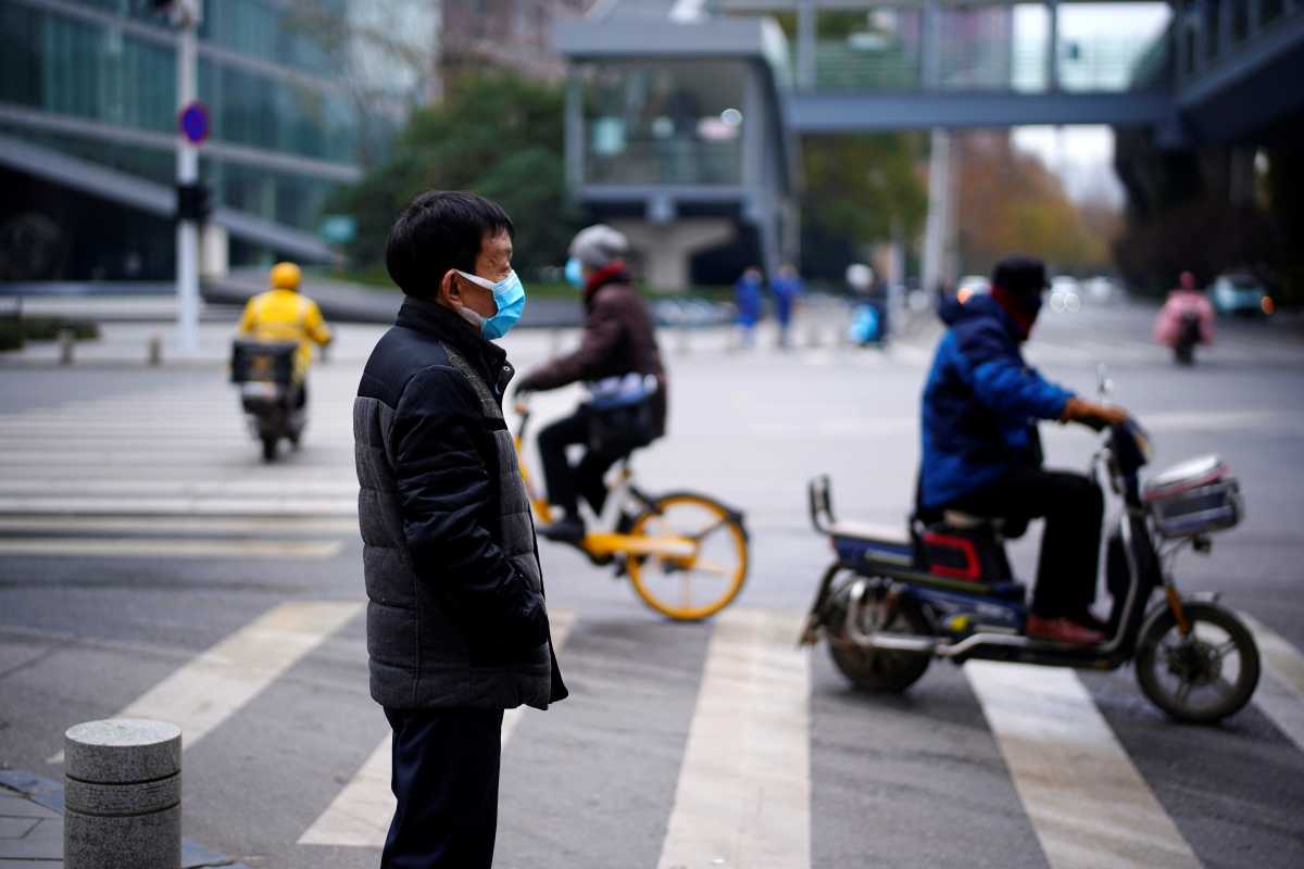 A man wearing a mask stands near a street, almost a year after the start of the coronavirus disease (COVID-19) outbreak, in Wuhan, Hubei province, China December 17, 2020. REUTERS