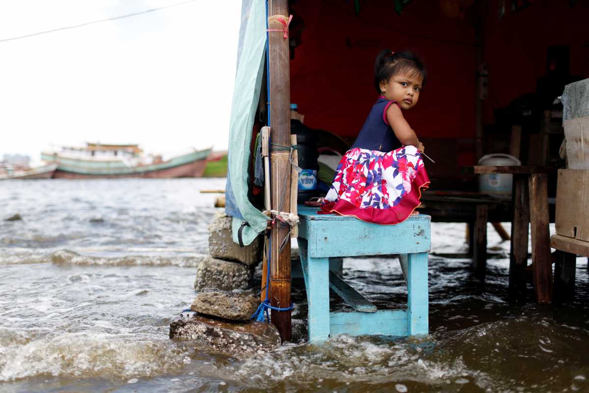 Shaqueena Dwi Arsyilla, 2, sits on a bench at Kali Adem port, which is impacted by high tides due to the rising sea level and land subsidence, north of Jakarta, Indonesia November 20, 2020. REUTERS