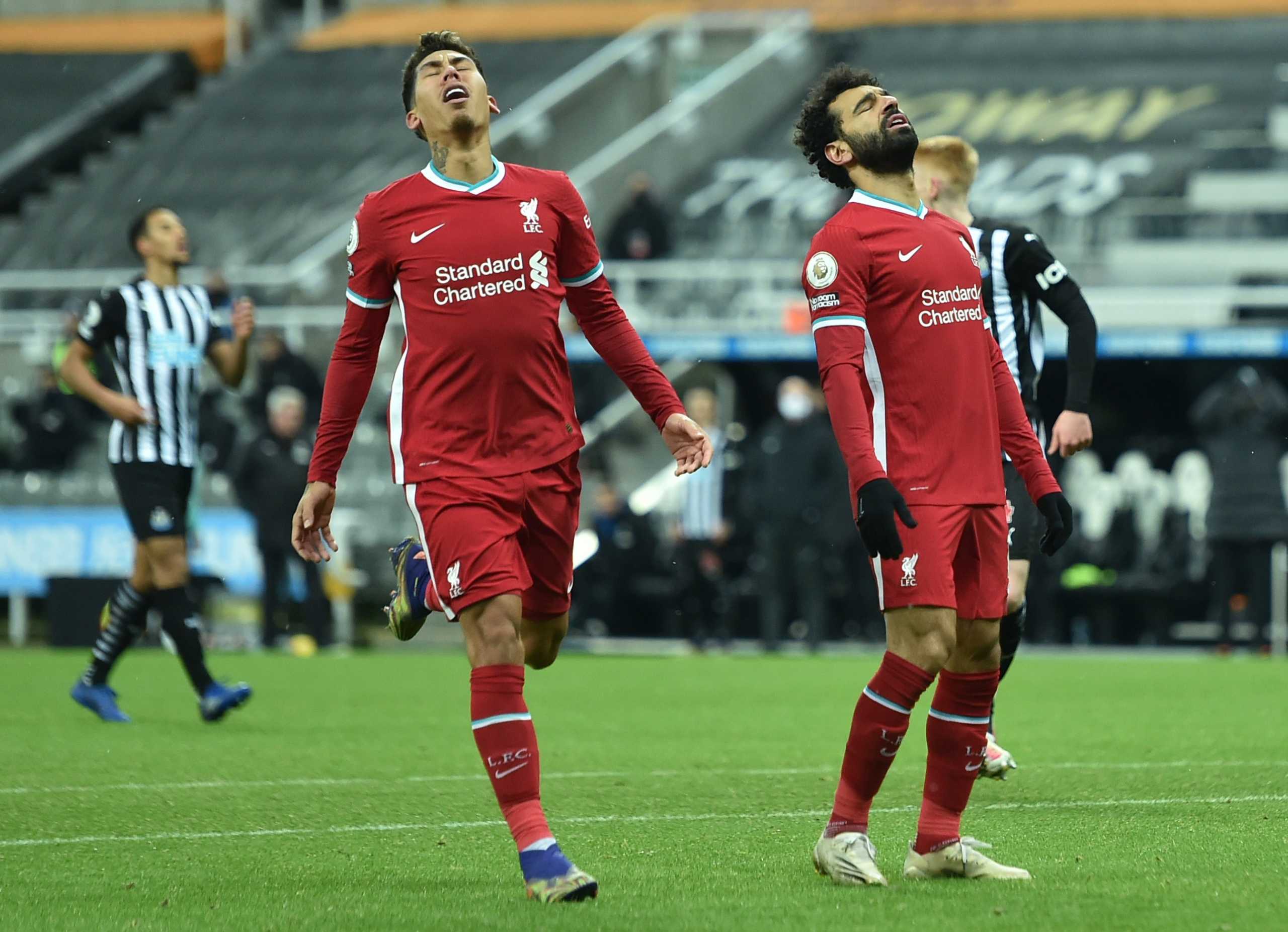 Soccer Football - Premier League - Newcastle United v Liverpool - St James' Park, Newcastle, Britain - December 30, 2020 Liverpool's Mohamed Salah and Roberto Firmino react Pool via REUTERS