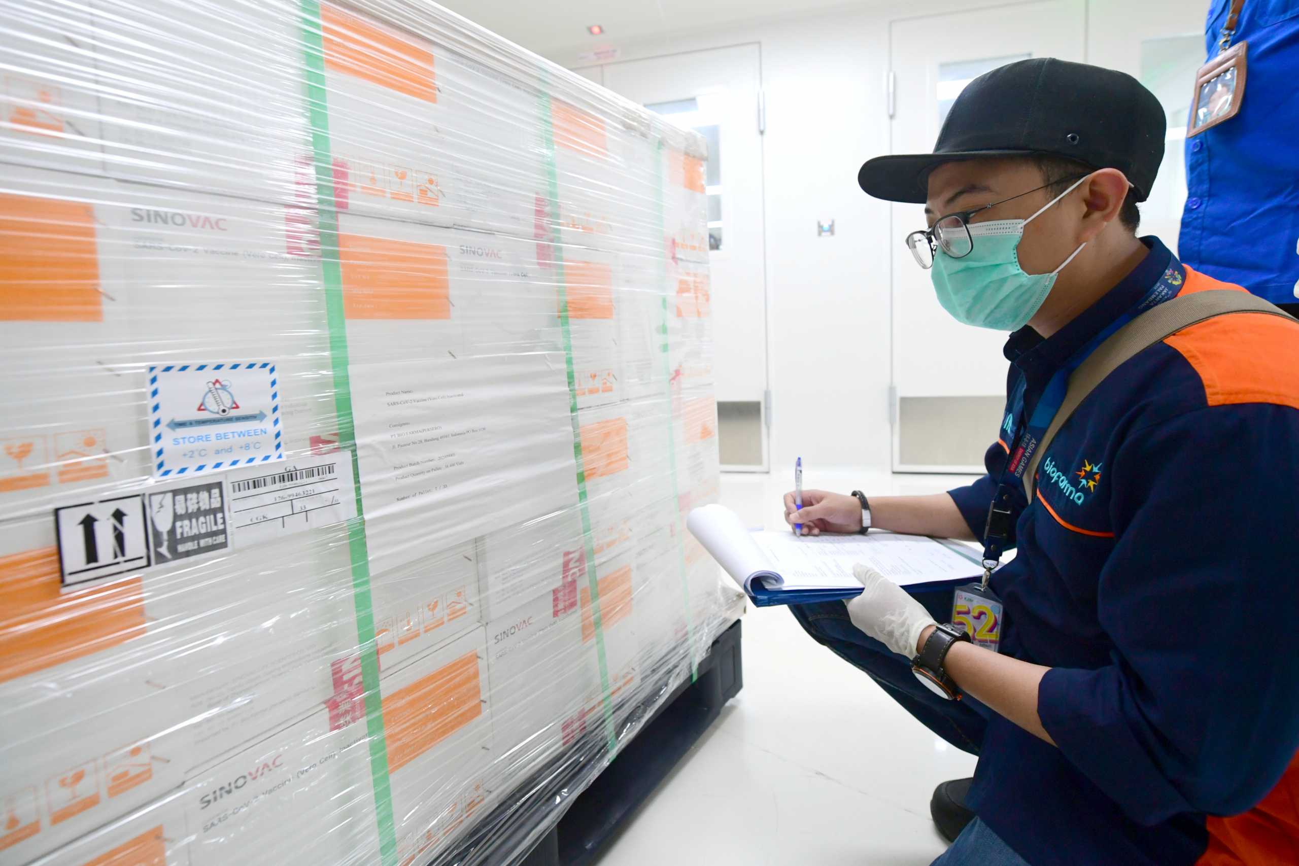An official checks on coronavirus disease (COVID-19) vaccines from China's Sinovac Biotech Ltd. as they arrive at PT Bio Farma (Persero) in the first shipment to Indonesia in Bandung, West Java province, Indonesia, December 7, 2020. Courtesy of Muchlis Jr