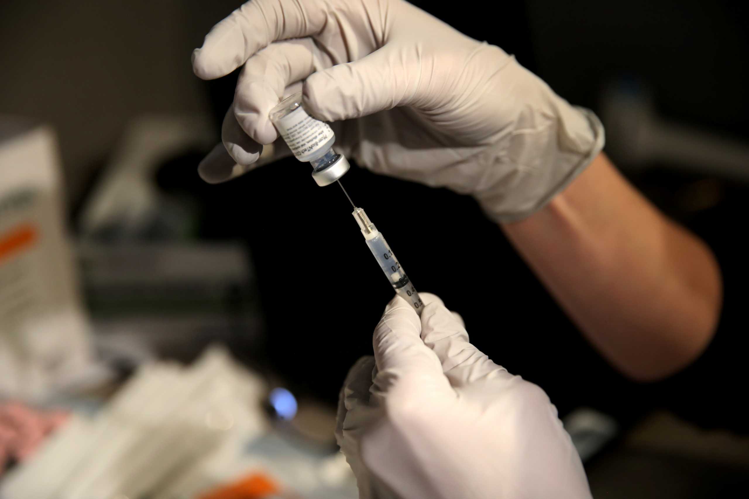 FILE PHOTO: Pharmacy manager Larren Suh prepares a dose of the Pfizer-BioNTech coronavirus disease (COVID-19) vaccine at Massachusetts General Hospital in Boston, Massachusetts, U.S., December 16, 2020.  Craig F. Walker