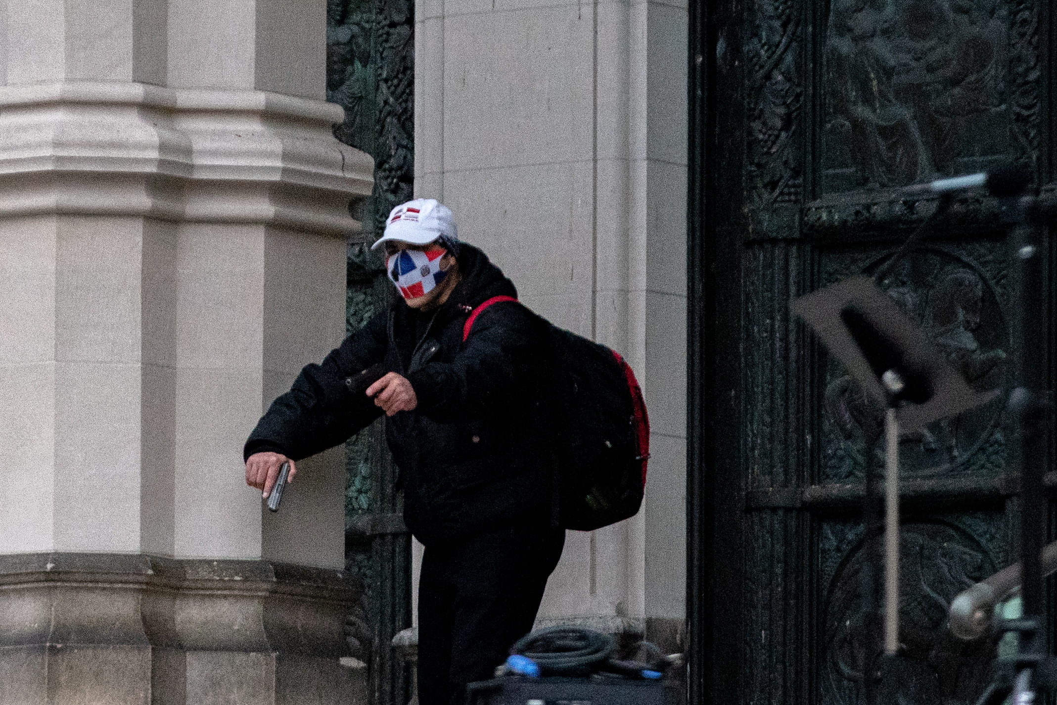 A man wearing a protective mask points his guns outside the Cathedral Church of St. John the Divine in the Manhattan borough of New York City, New York, U.S., December 13, 2020. REUTERS