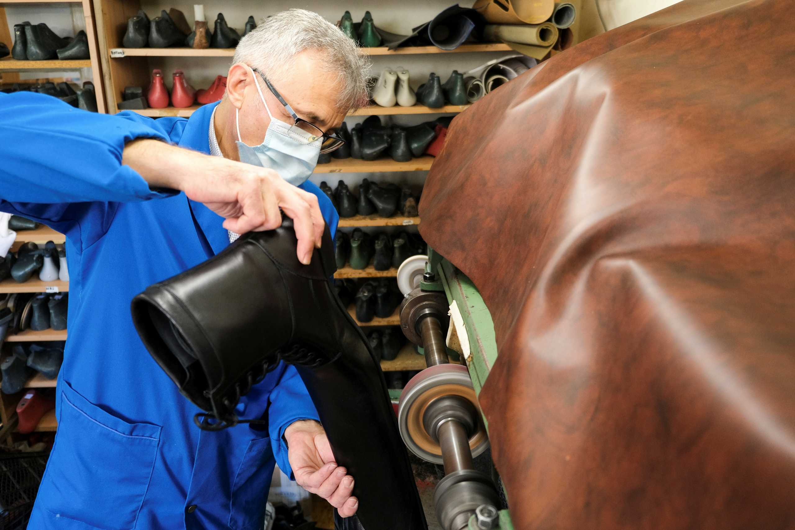 Romanian cobbler Grigore Lup polishes the soles of a pair of oversized winter boots while working on them, in his workshop in Cluj-Napoca, Romania, December 2, 2020. Picture taken December 2, 2020. Inquam Photos