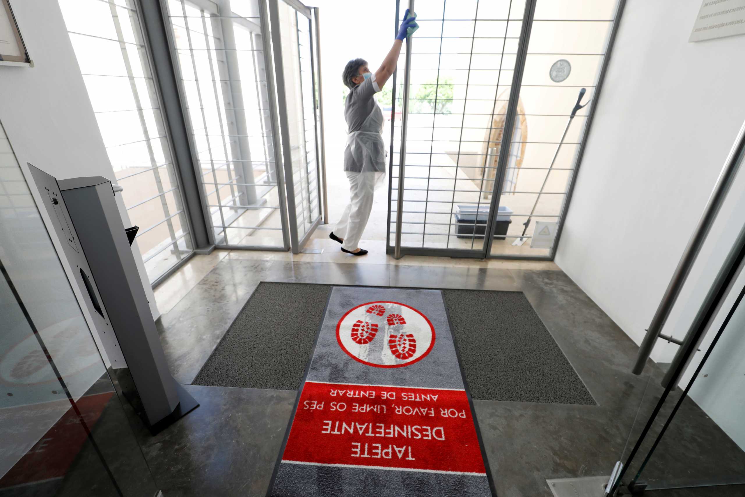 FILE PHOTO: A cleaner works at the entrance of Pousada Castelo Hotel  during the coronavirus disease (COVID-19) outbreak, in Alcacer do Sal, Portugal June 3, 2020. REUTERS